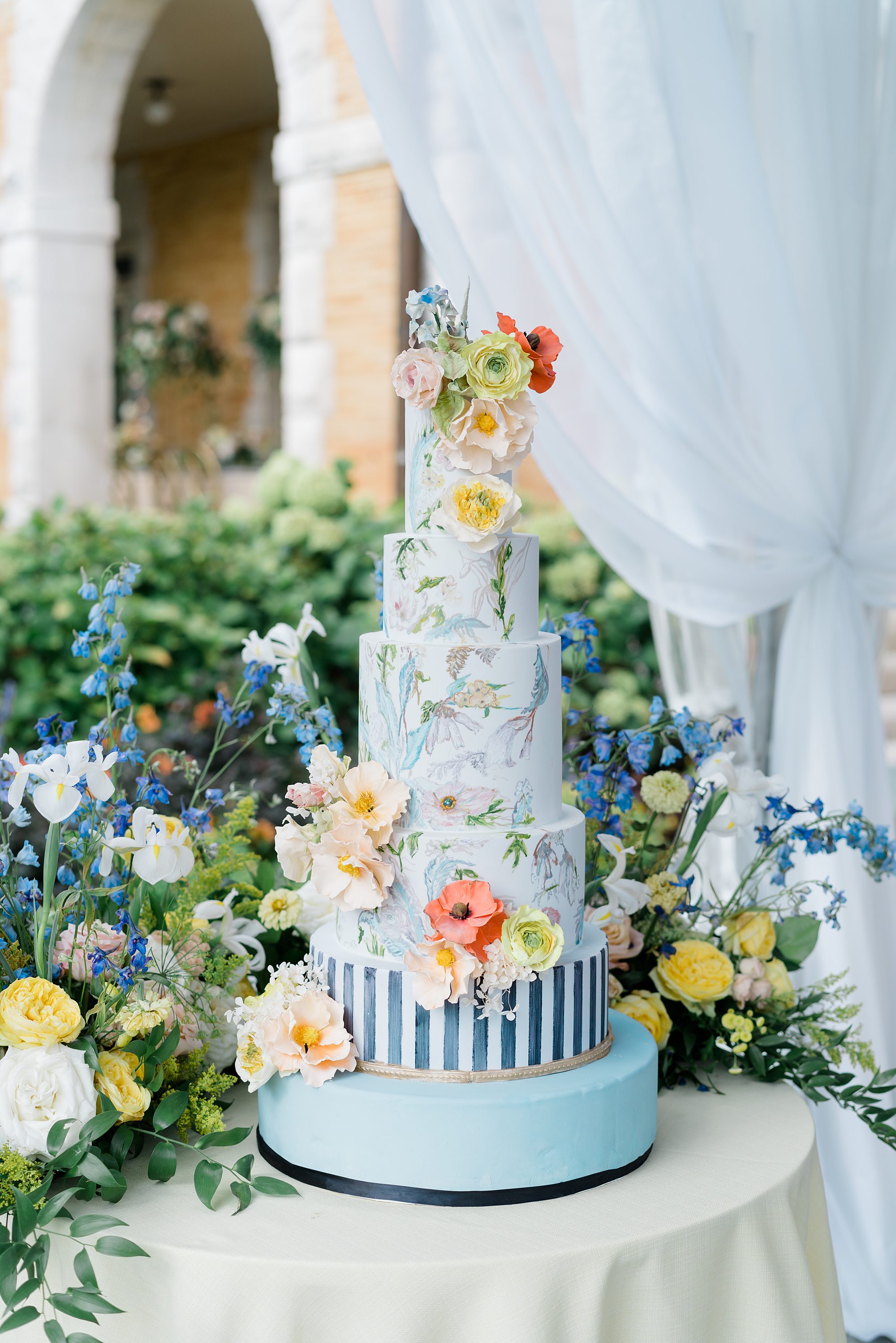 5 tier blue wedding cake with flower decor