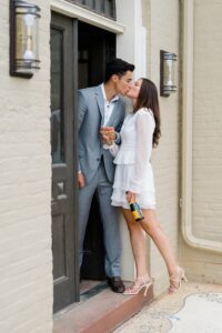 engaged couple kiss in mansion doorway