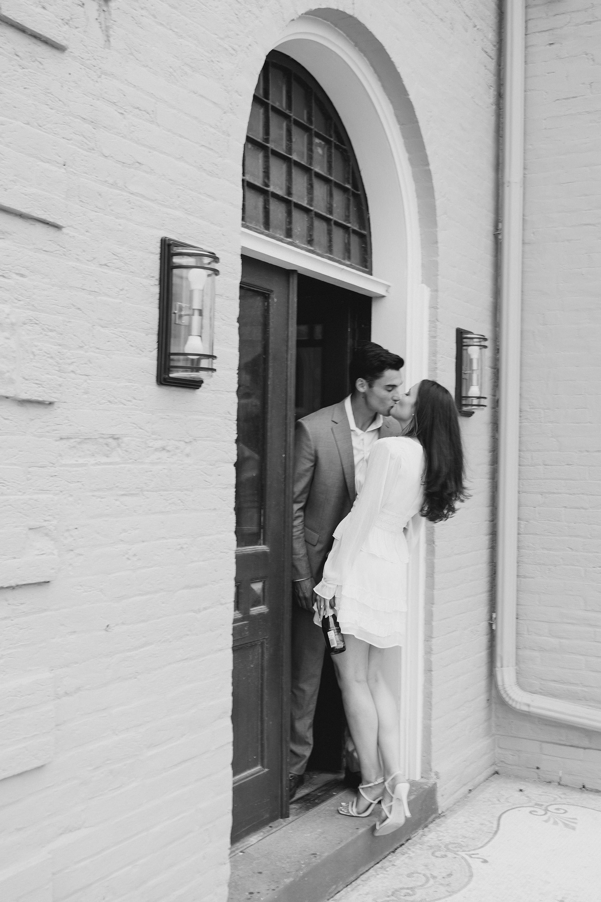 engaged couple kiss in the doorway