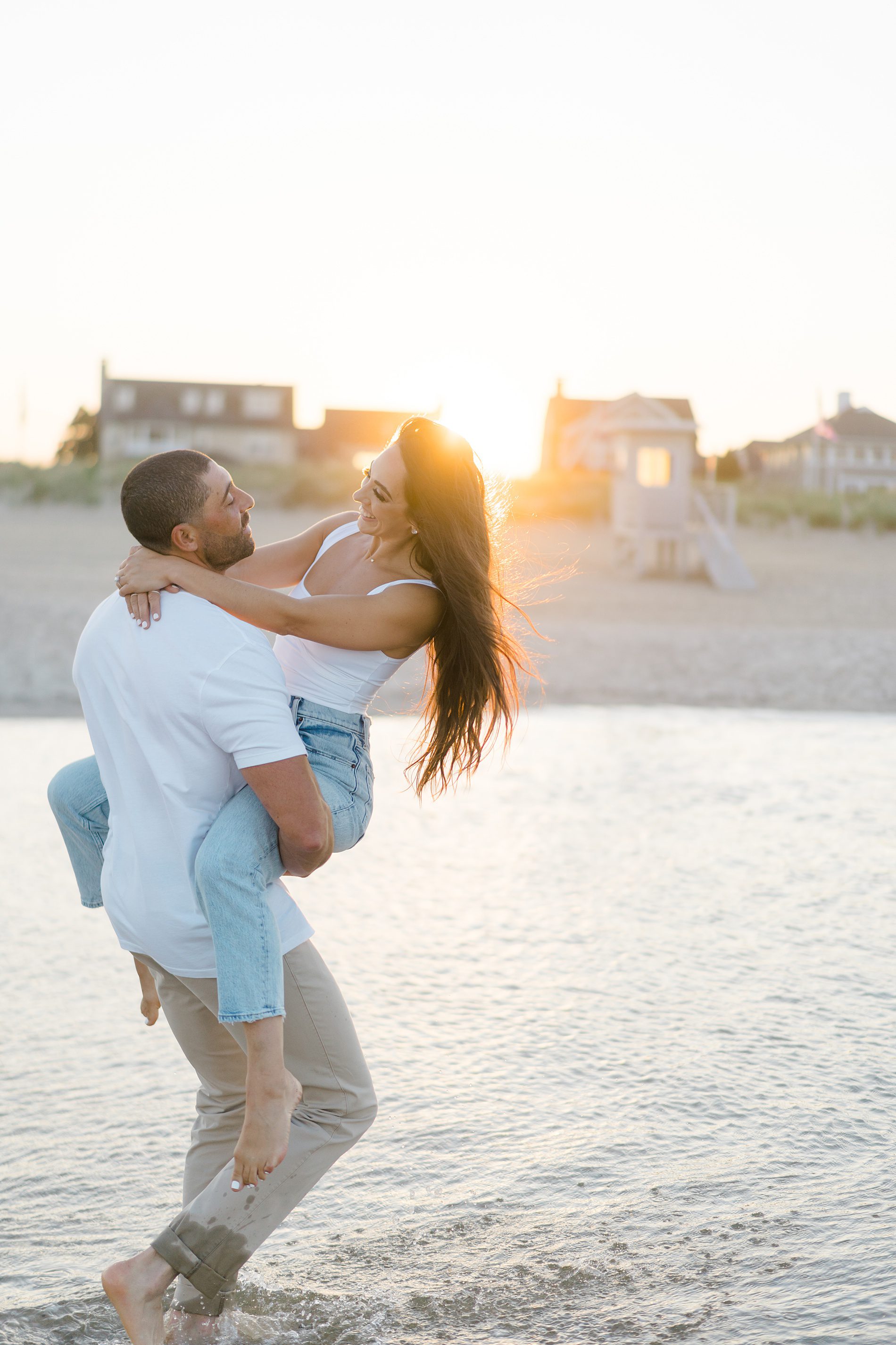 couple in the ocean during beach engagement photos at sunset