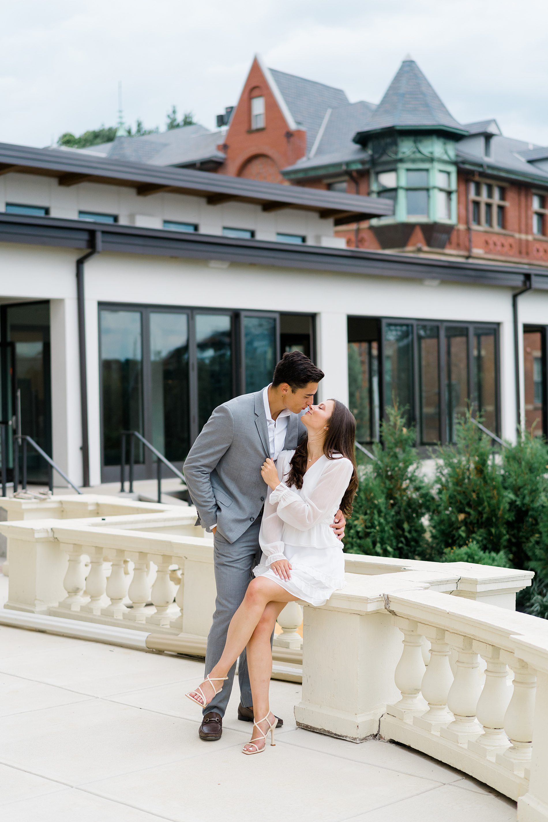 engaged couple kiss on balcony of Wilbur Mansion