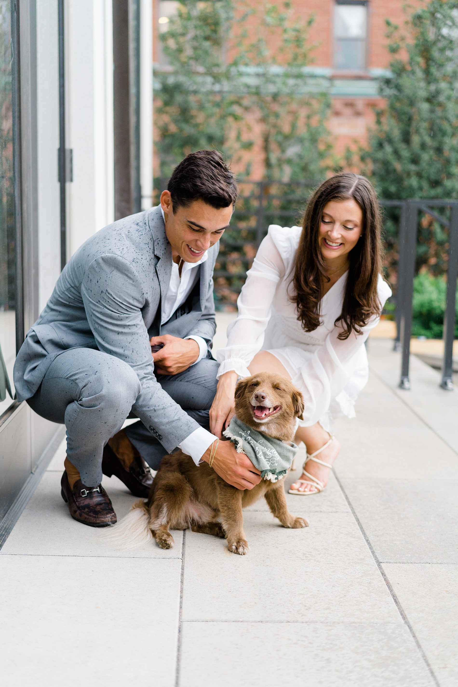 couple pet their dog during engagement session