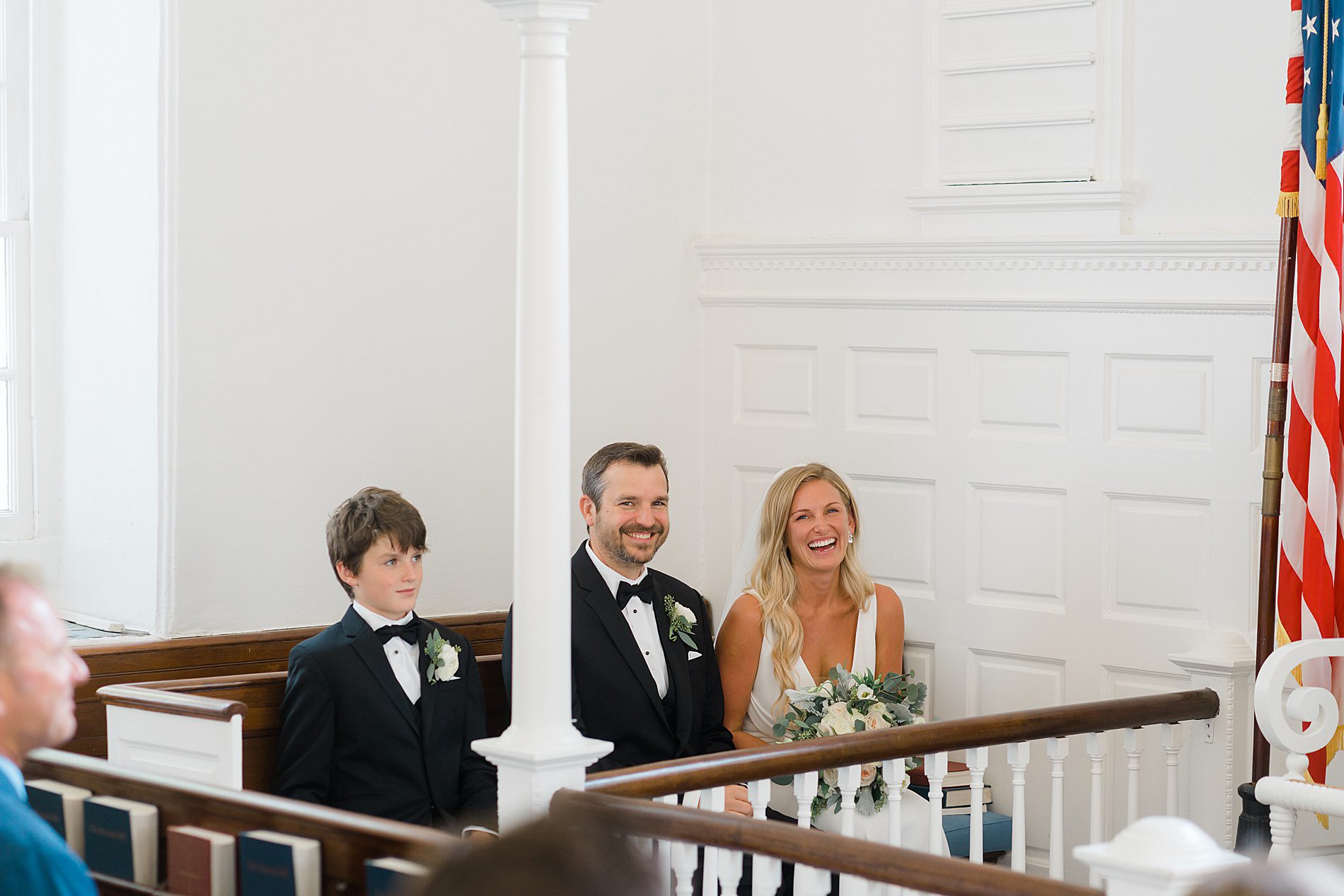 couple and son sit in church pew at wedding