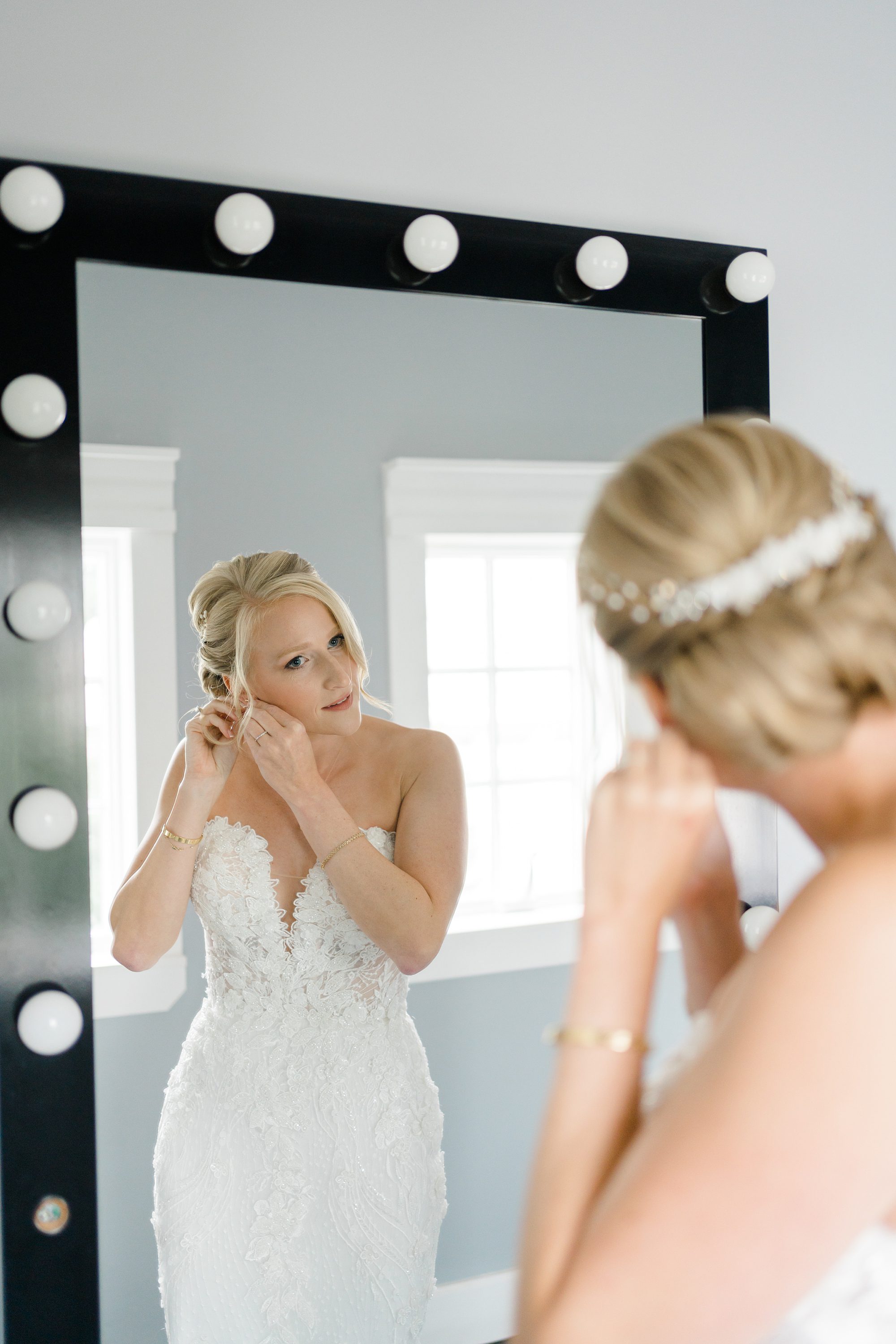 bride puts in earings before elegant garden inspired wedding at the Ryland Inn