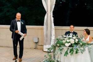 newlyweds listen to wedding toasts at reception
