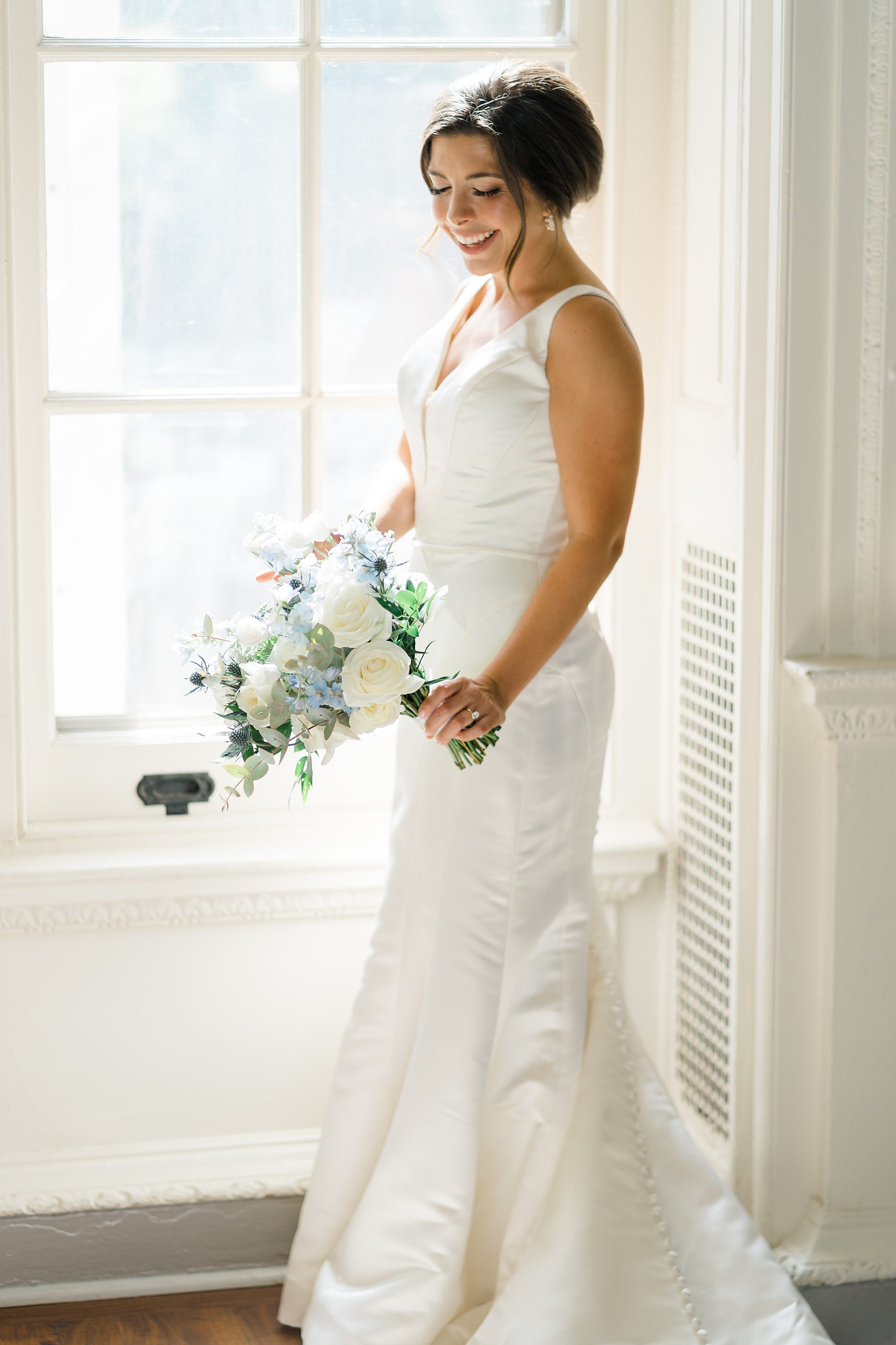 bride in long wedding dress holding white wedding bouquet