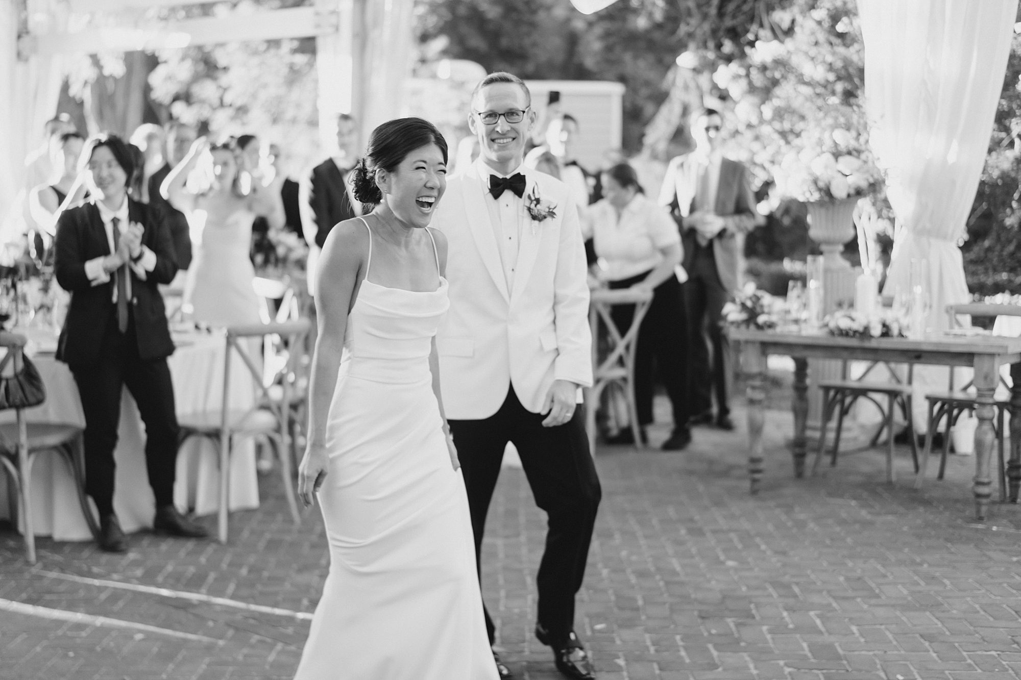 couple laugh together at wedding reception