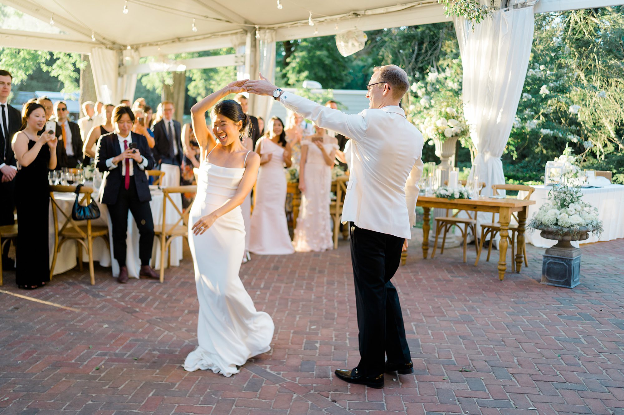 groom twirls his bride around on the dance floor
