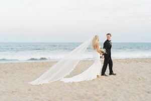 newlyweds walk on the beach holding hands