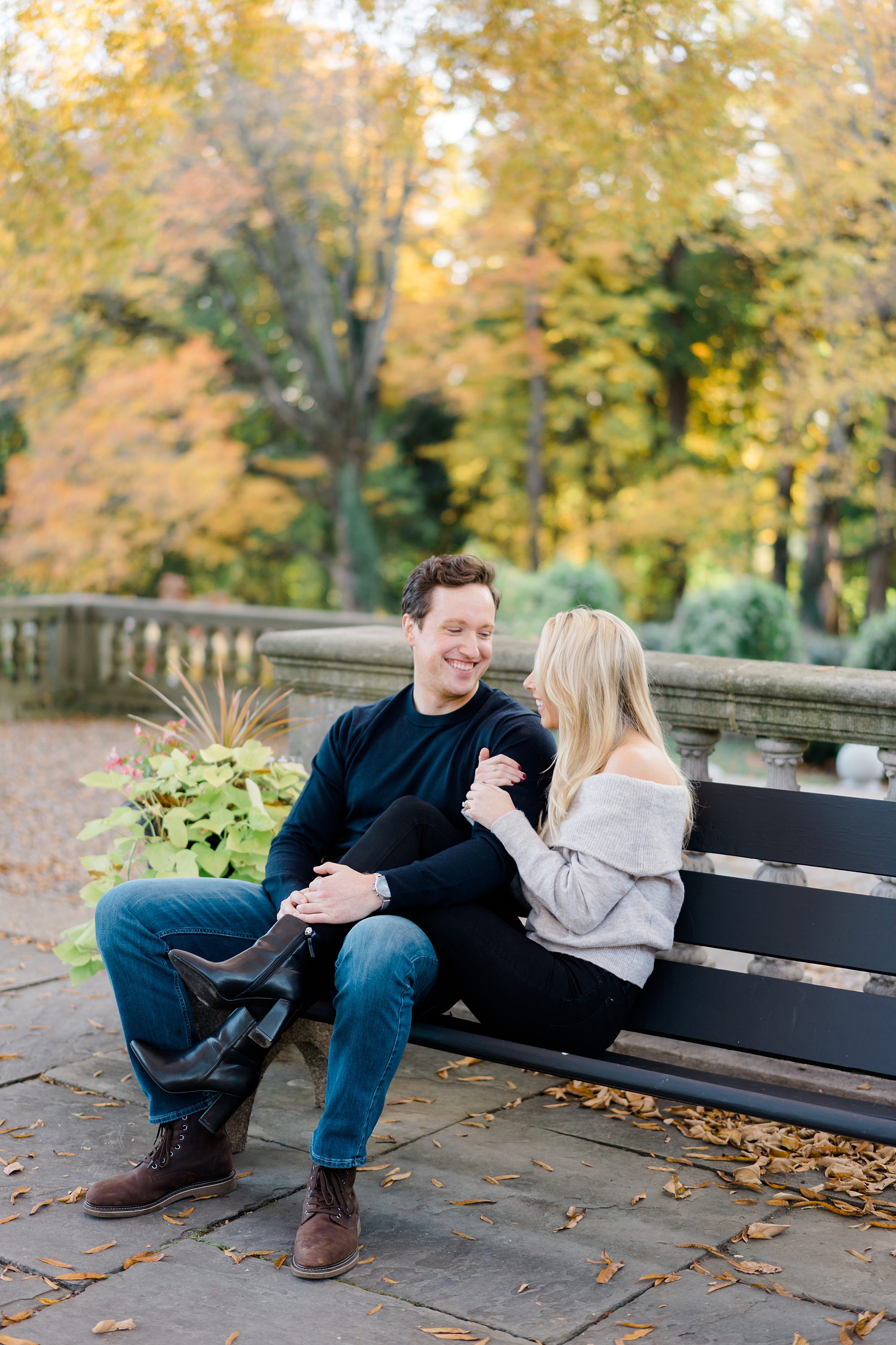candid engagement photos of couple sitting on bench