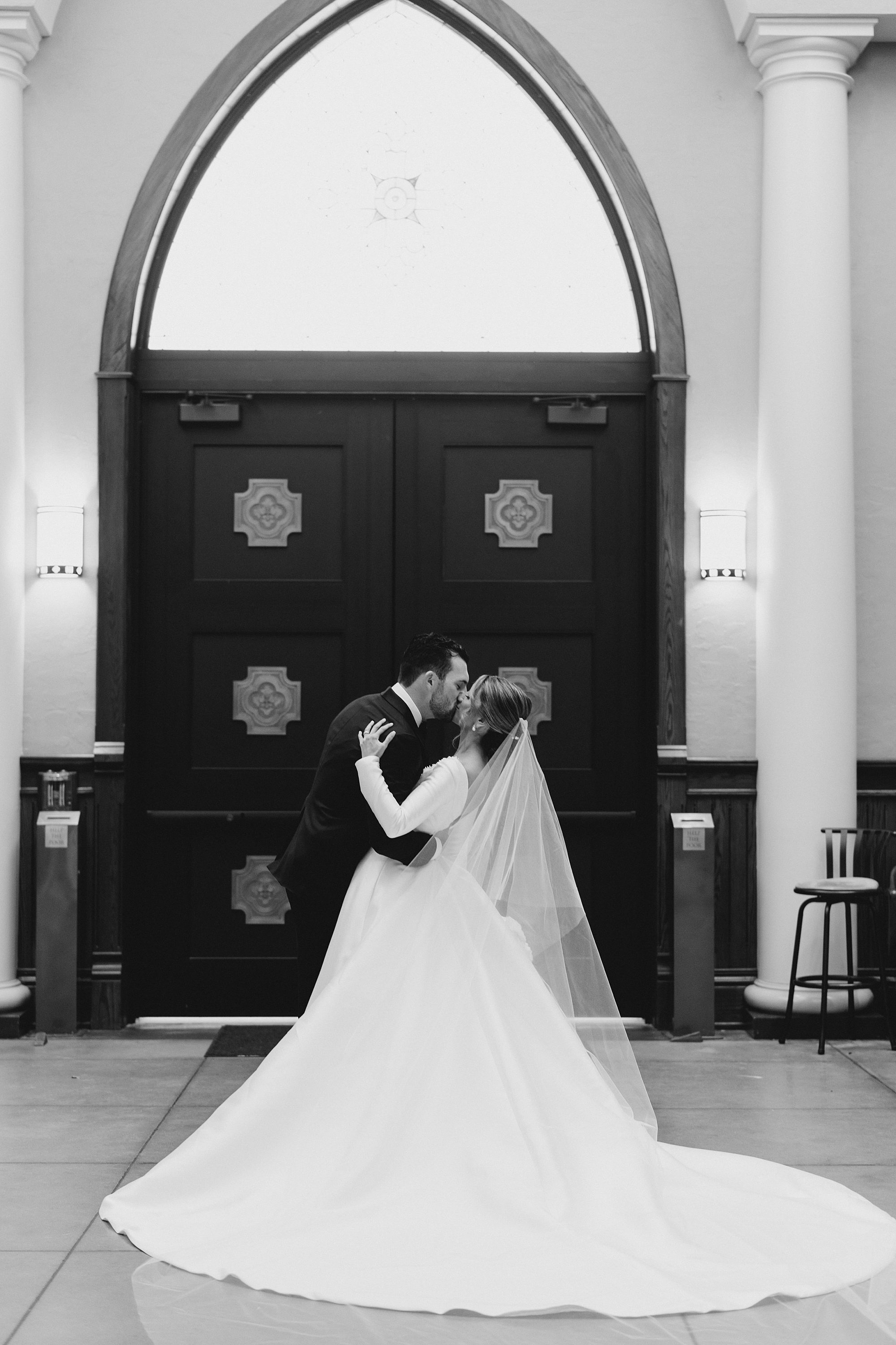 couple kiss outside church doors