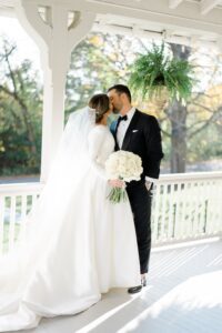 bride and groom kiss on porch of Cross Gables Estate