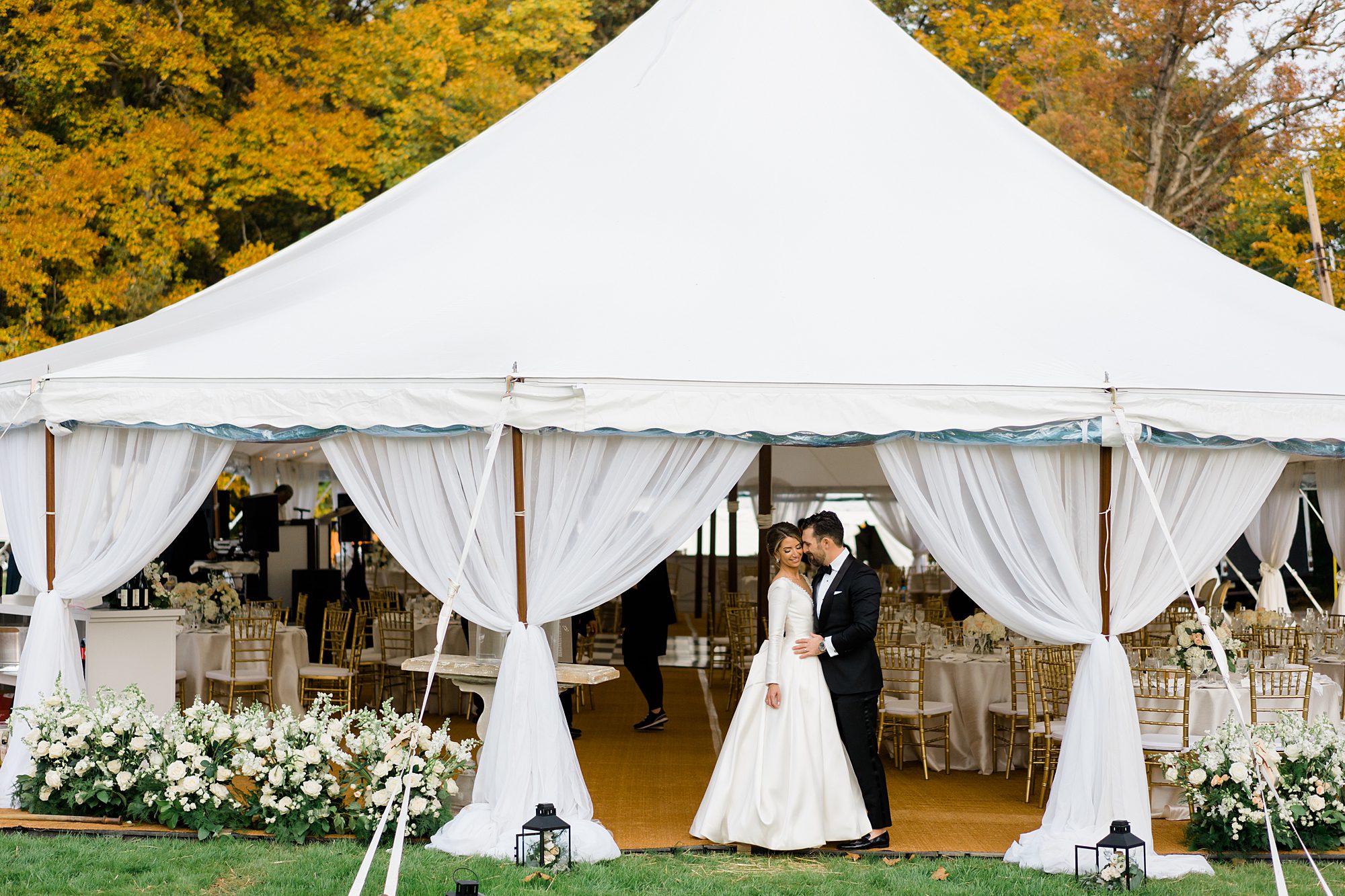 couple stand outside tented reception