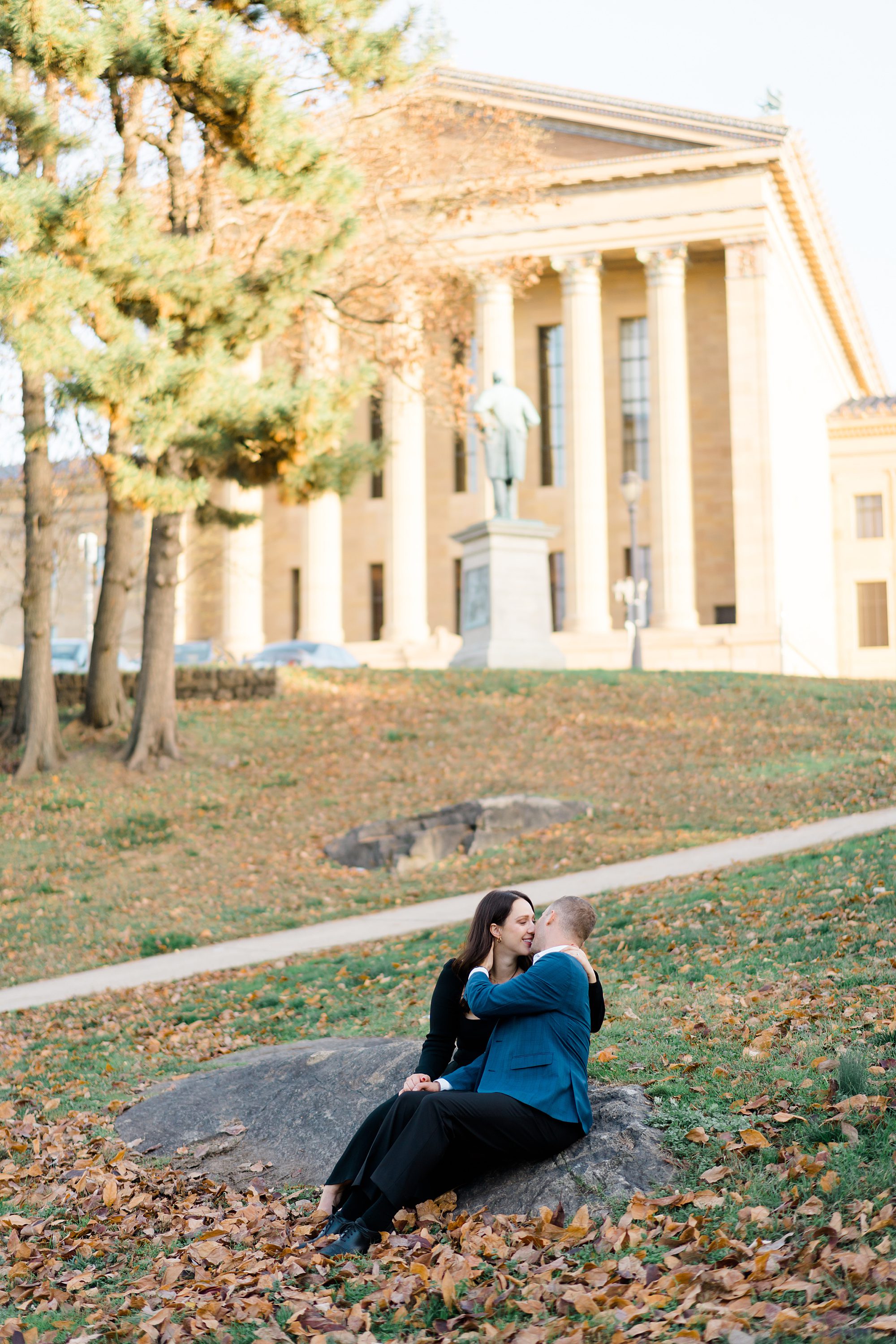 couple sit on the grounds of Philadelphia Art Museum during Engagement