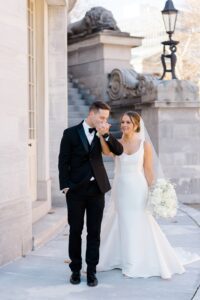 groom kisses brides hand as they walk together