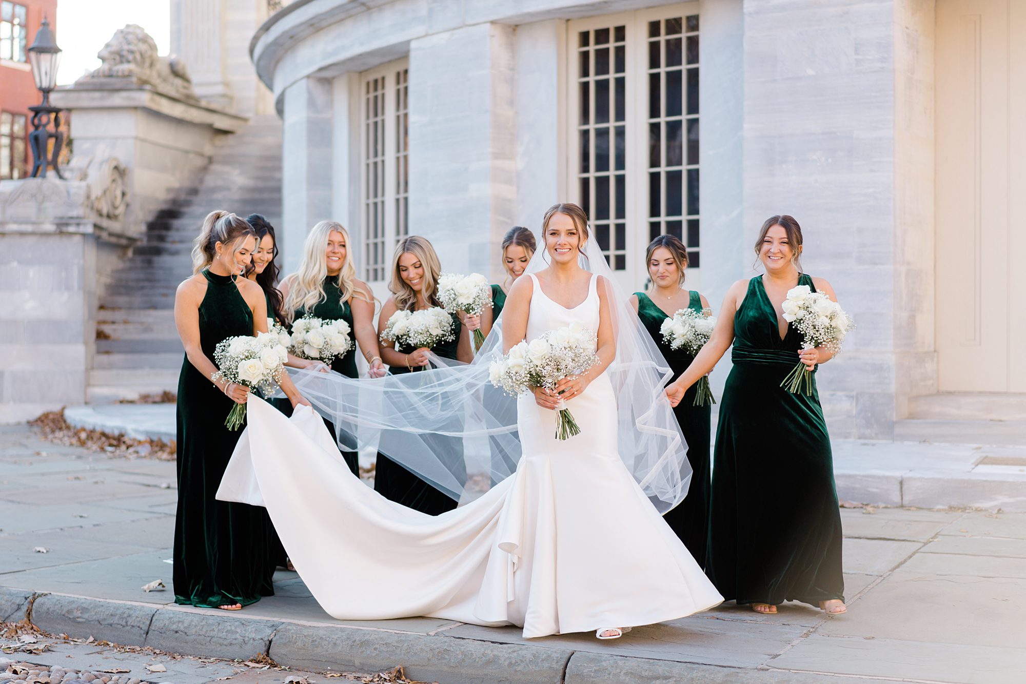 bridesmaids hold out bride's wedding dress