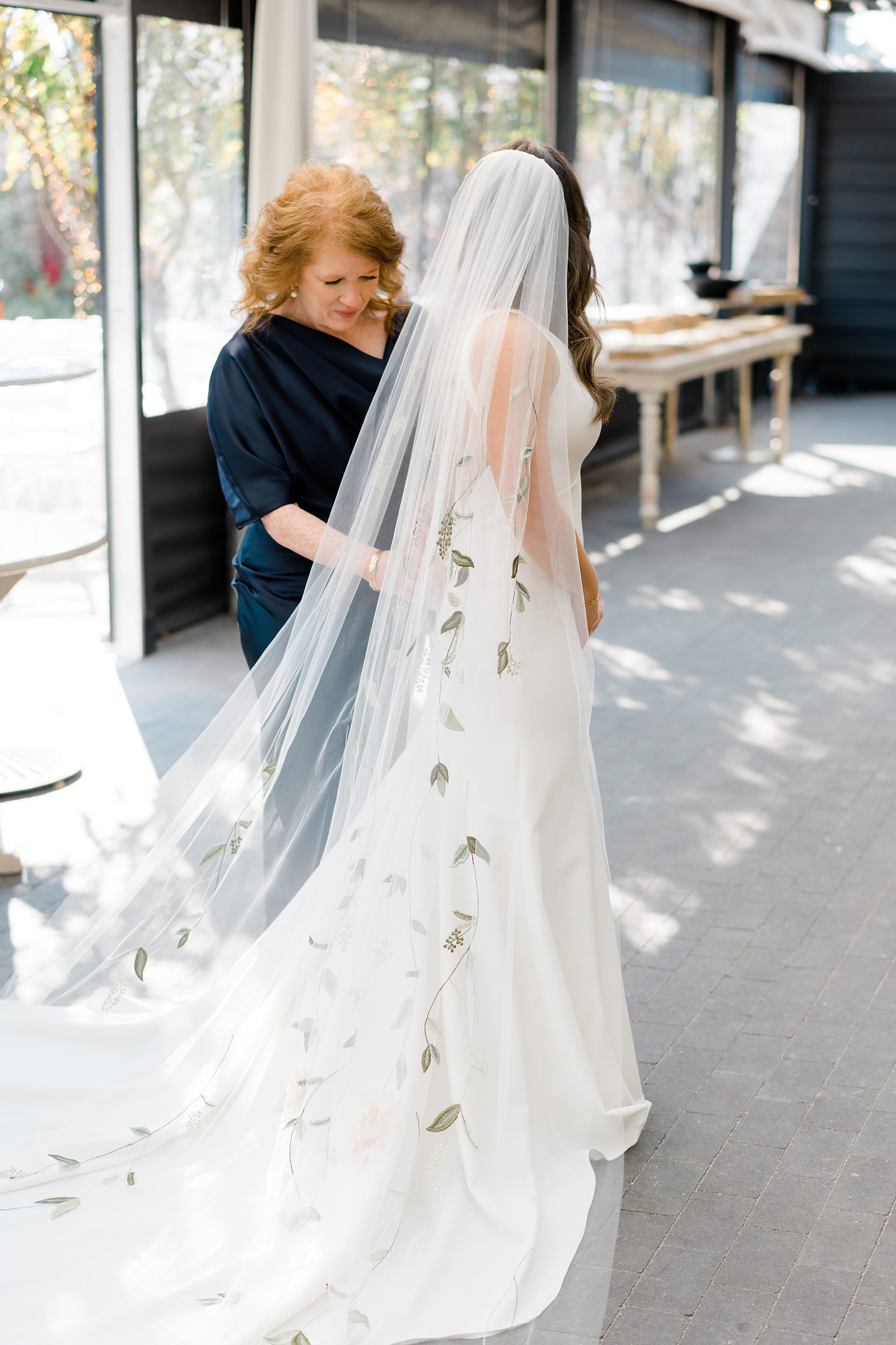 mom helps bride into wedding dress