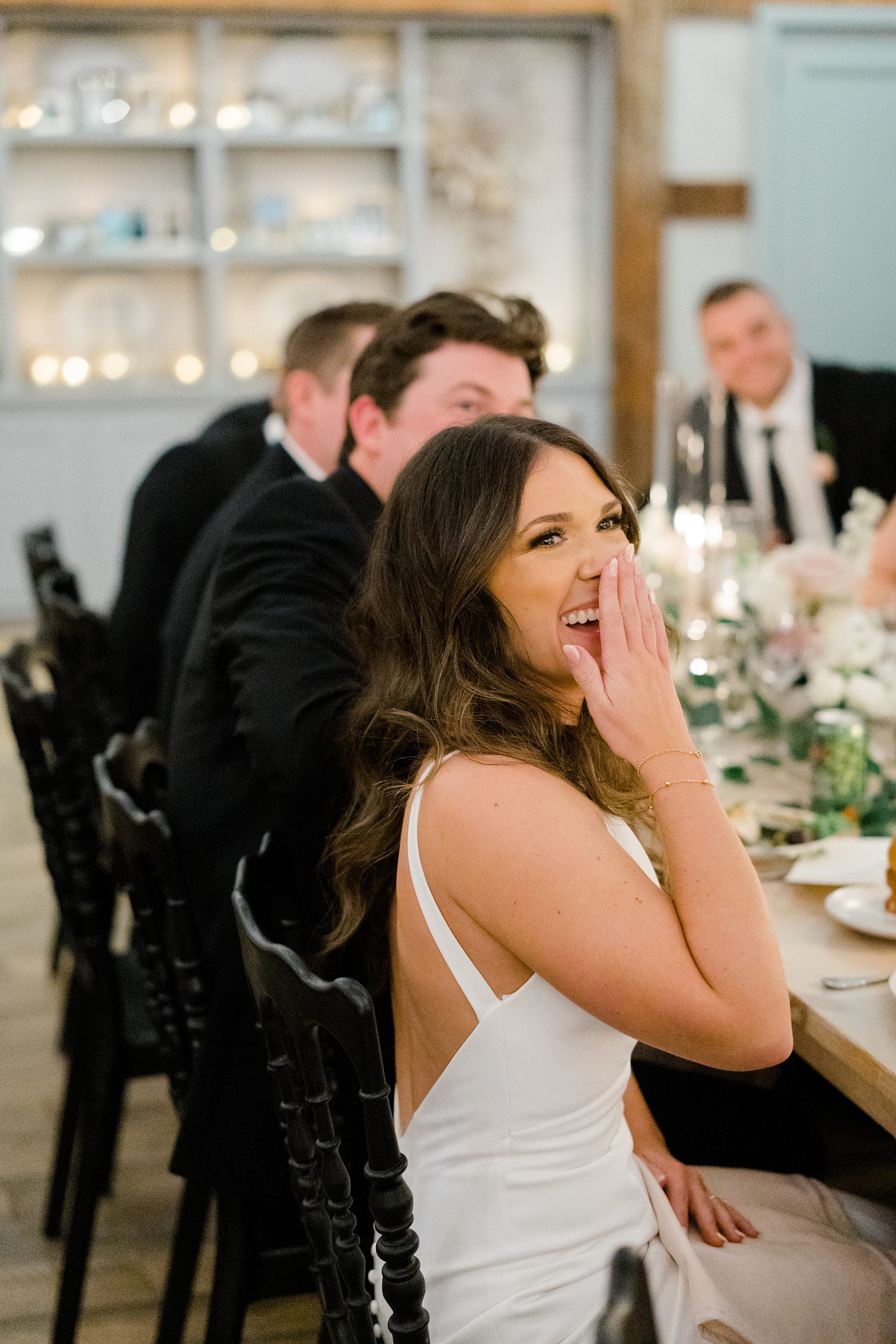 bride laughs listening to wedding speech
