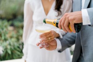 engaged couple pour champagne during engagement session with wedding photographer
