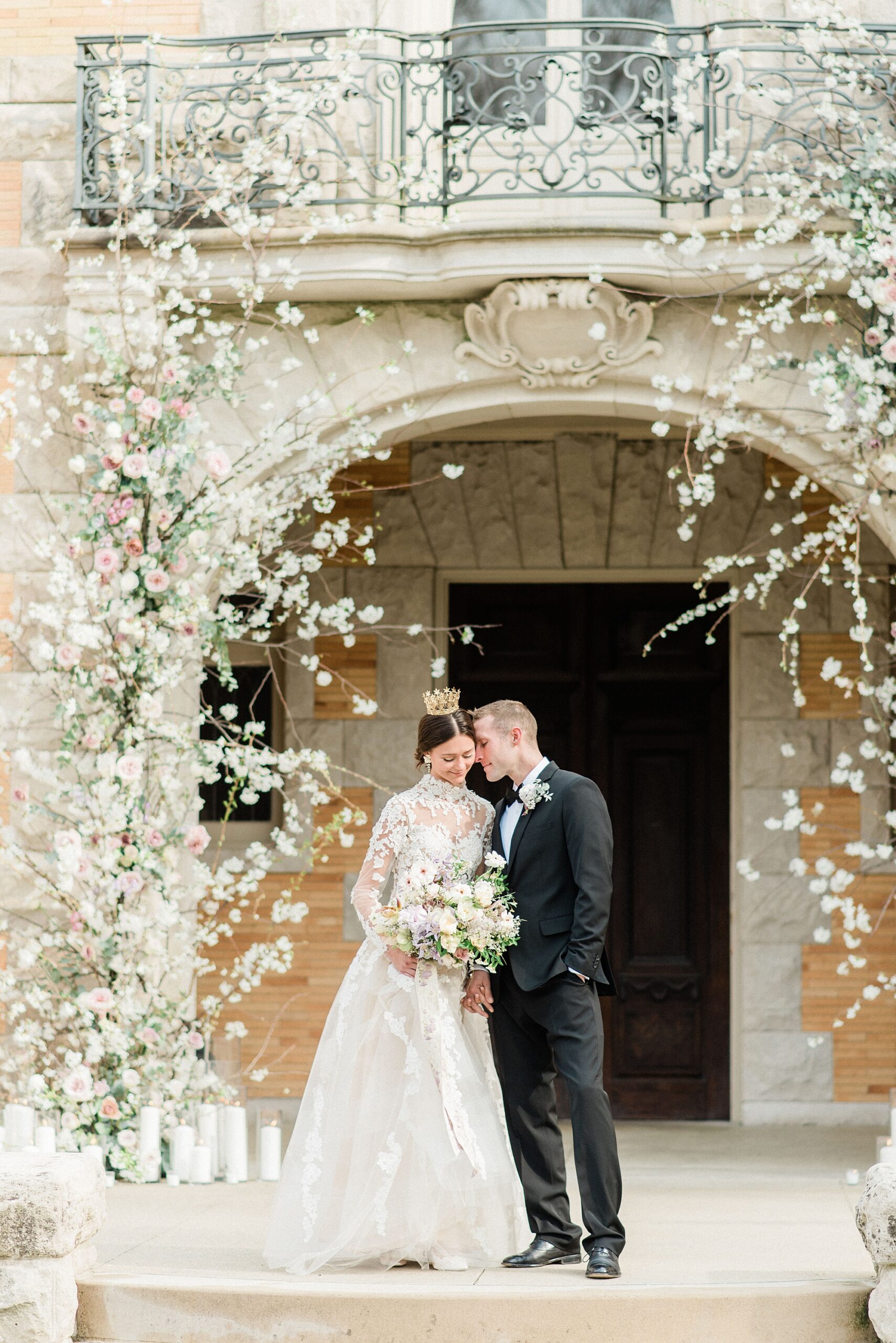 couple at entrance of Cairnwood Estate surrounded by enchanting white flower arrangement