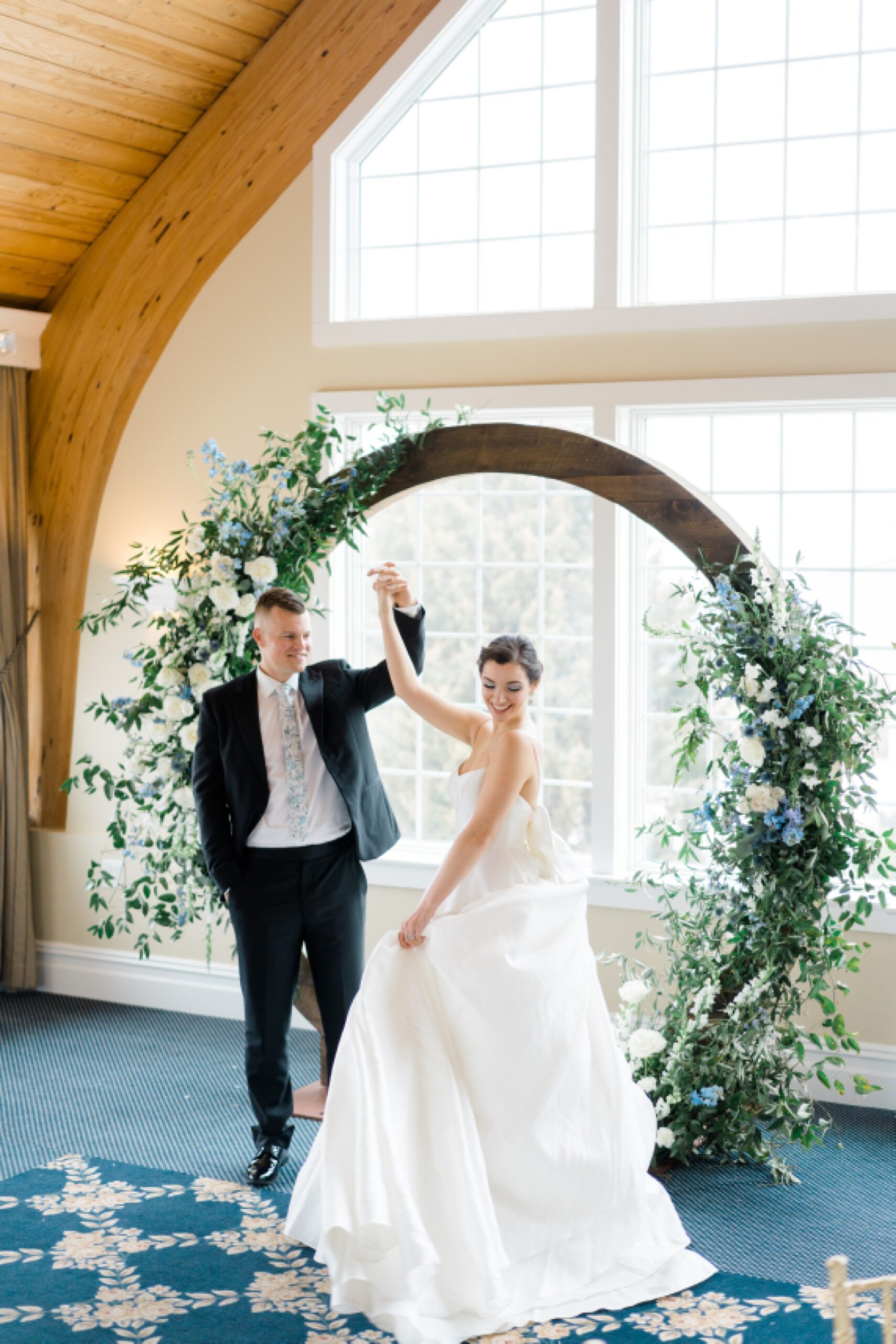bride and groom in front of circular wedding arch 