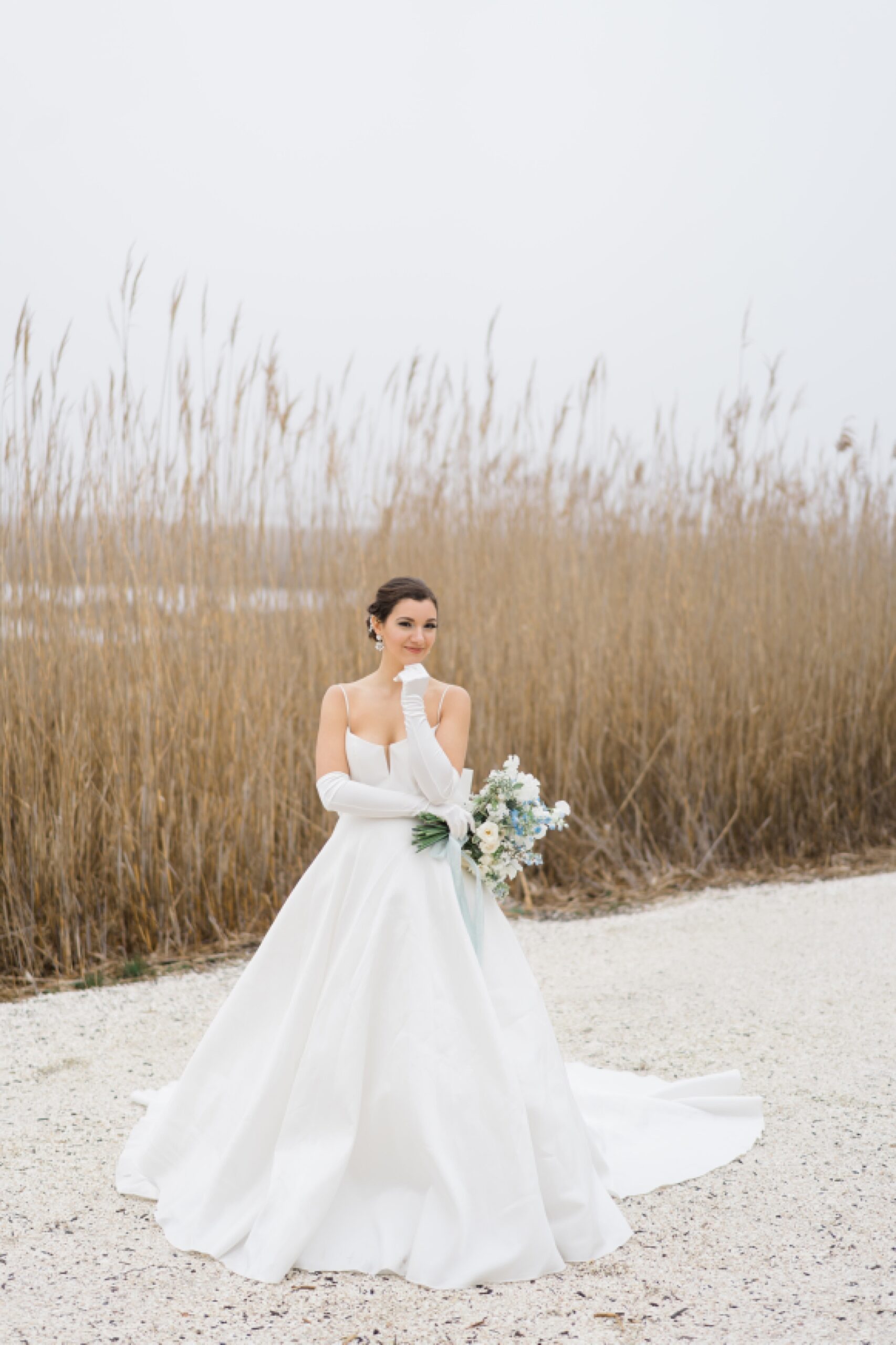 bride stands by tall grass 