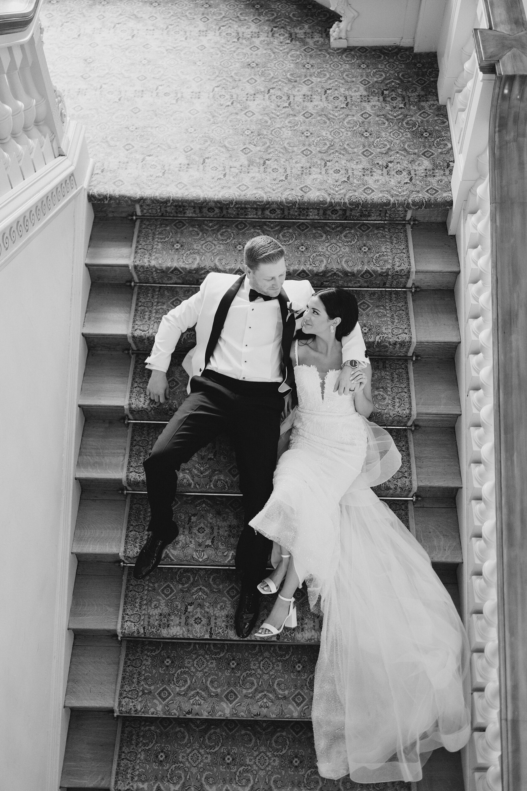aerial photo of bride and groom laying on stair case 