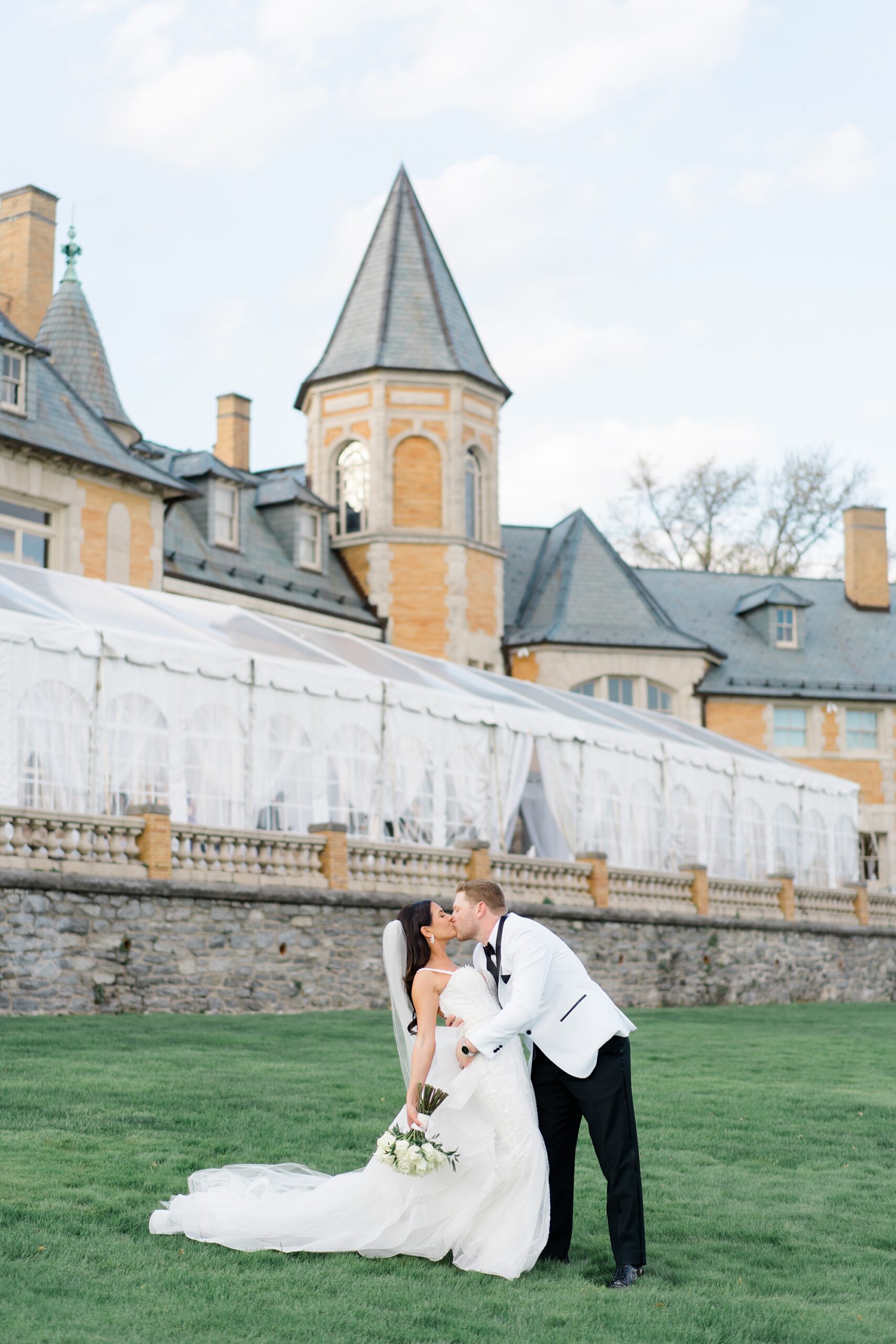 couple kiss outside of Cairnwood Estate during wedding portraits 