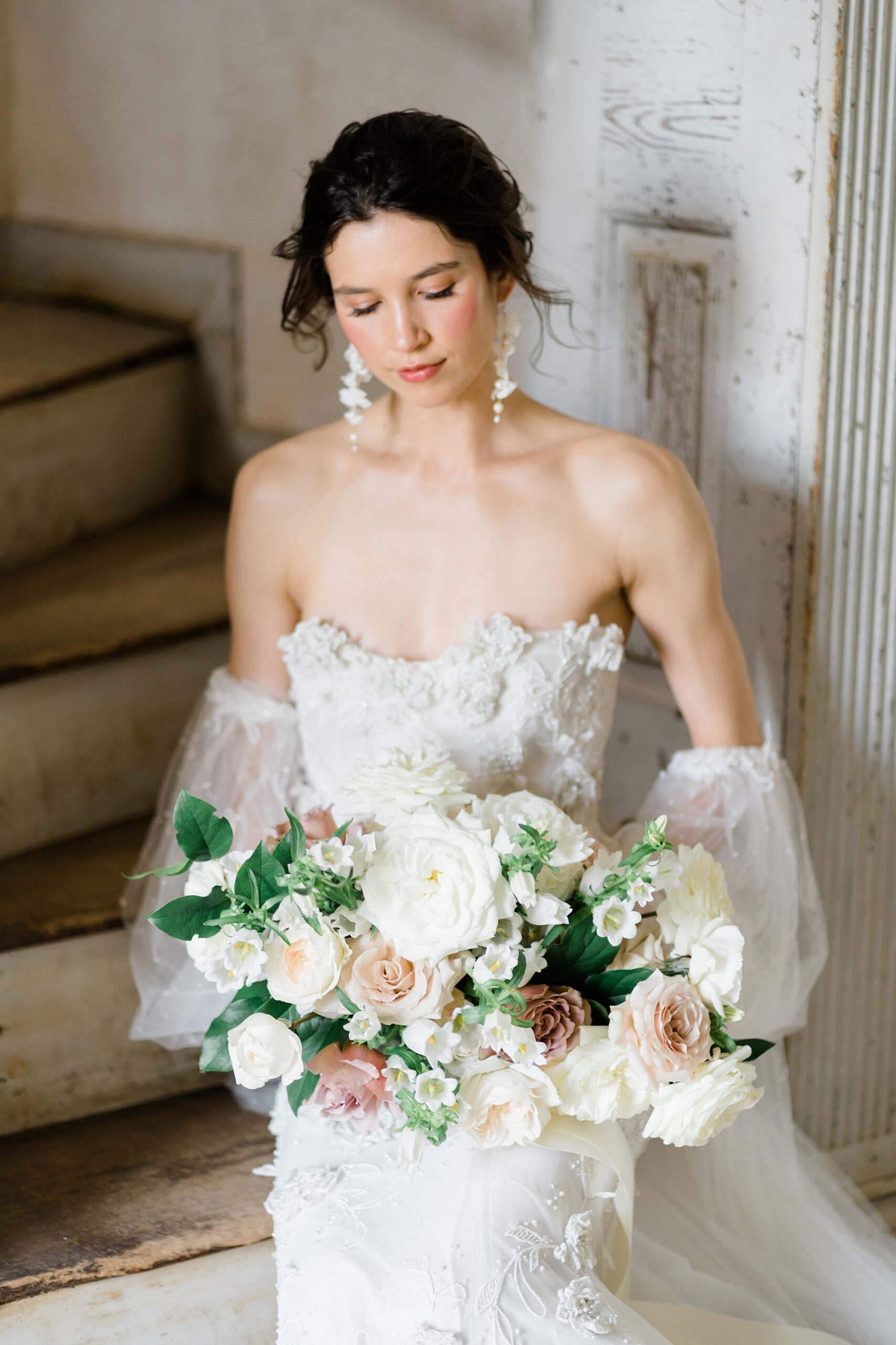 bride looks down at bouquet