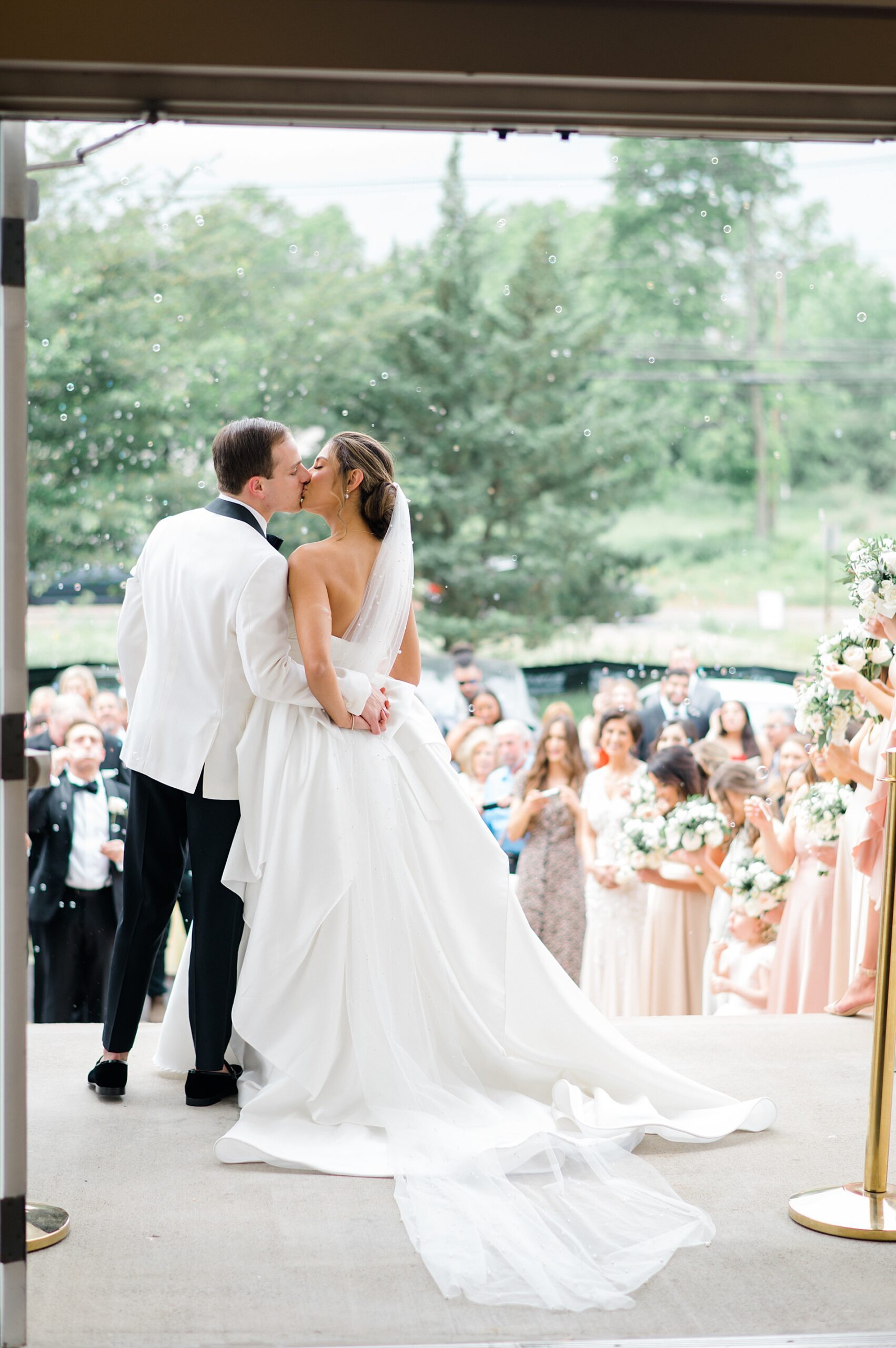 couple kiss as they exit wedding ceremony