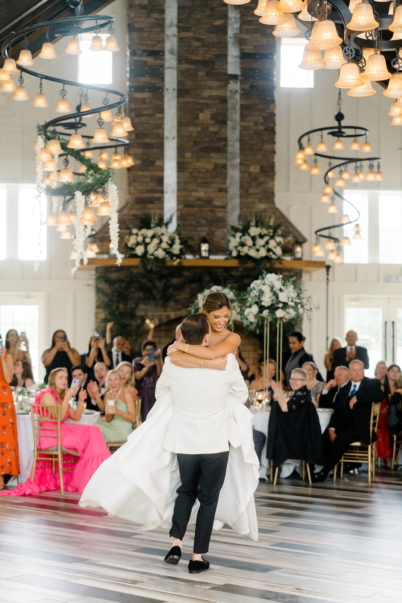 groom lifts bride up during first dance