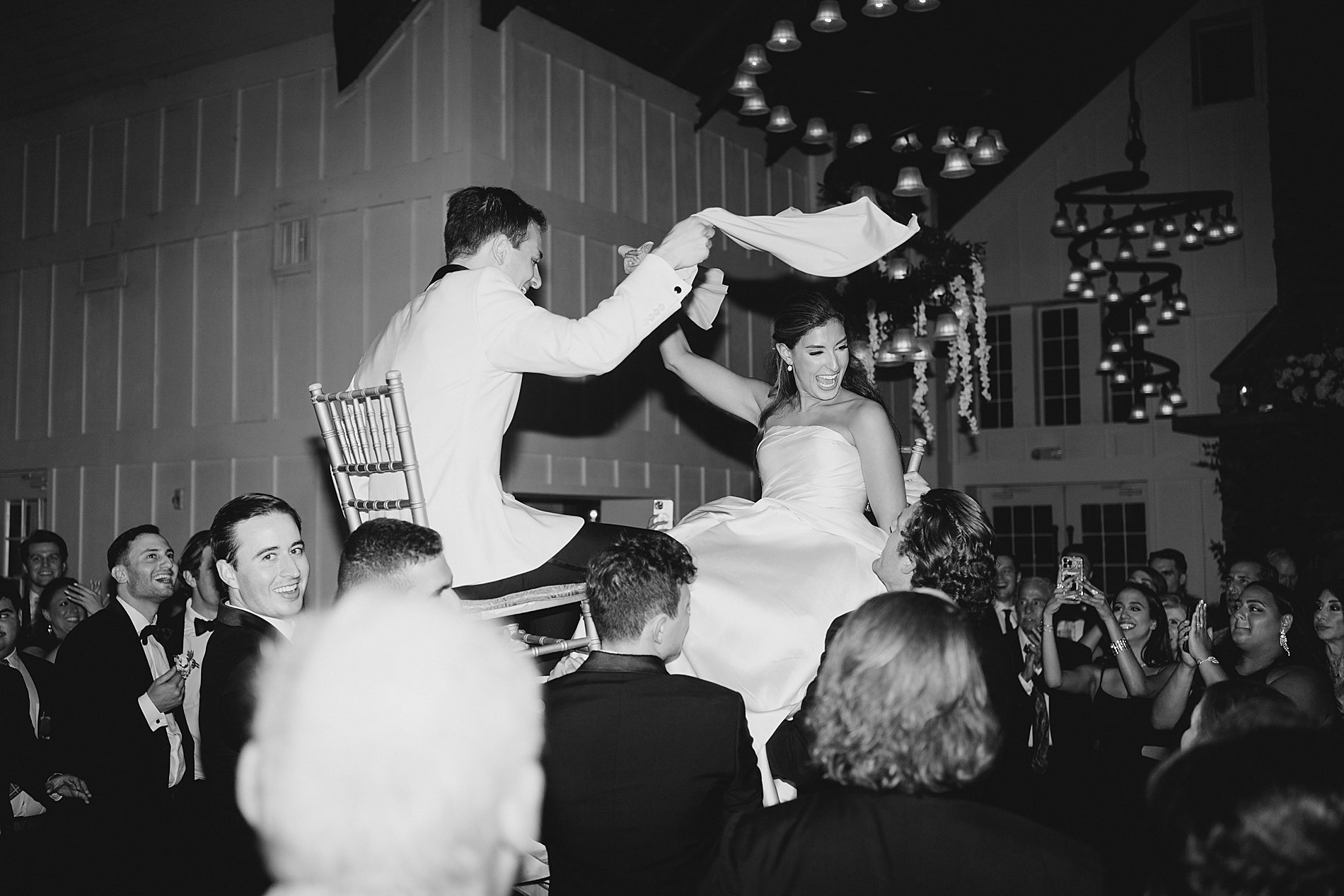 bride and groom are lifted up in chairs on the dance floor