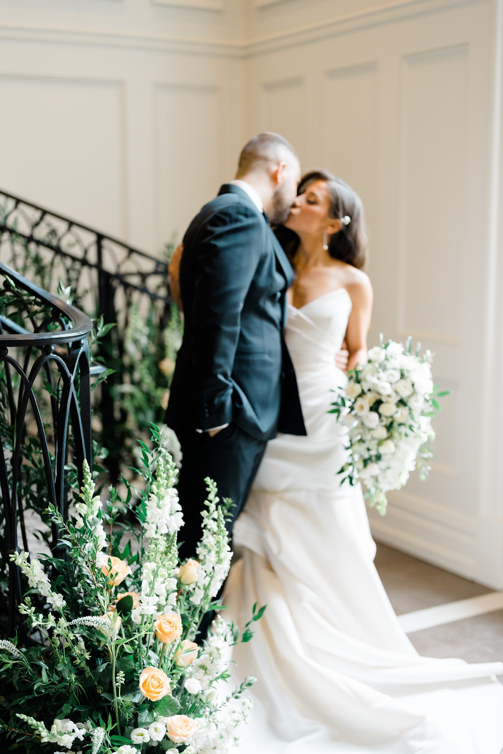 couple kiss near staircase at Estate at Florentine Gardens Wedding