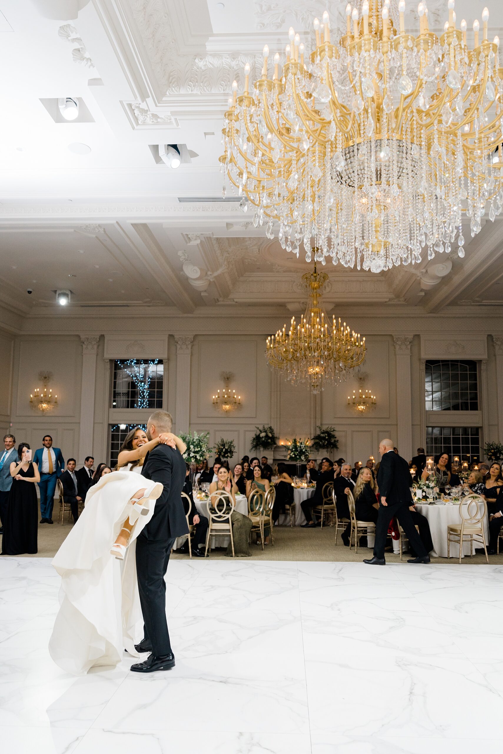 groom holds bride in his arms on dance floor of Estate at Florentine Gardens Wedding