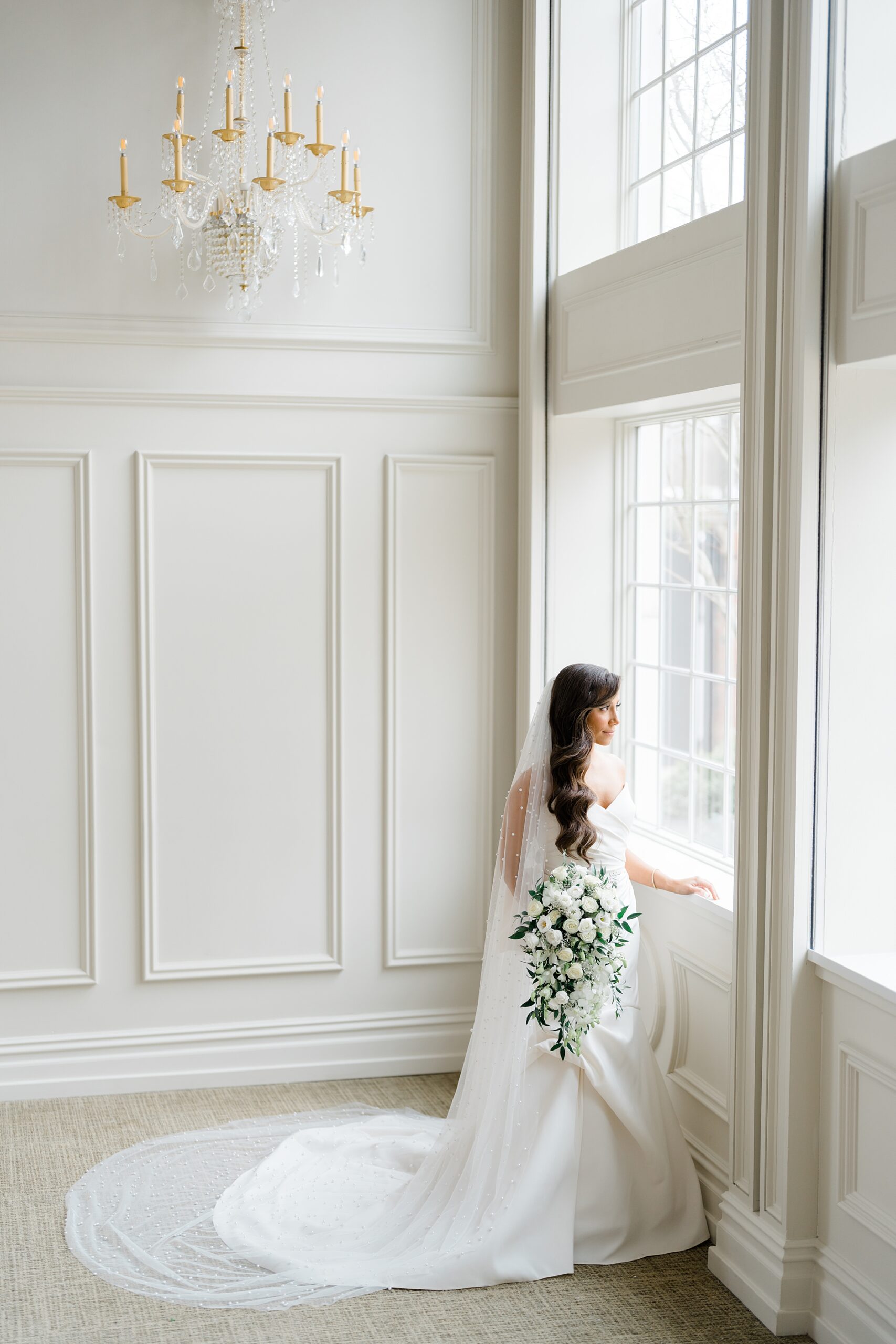 bride looks out of window as she gets ready for Estate at Florentine Gardens Wedding