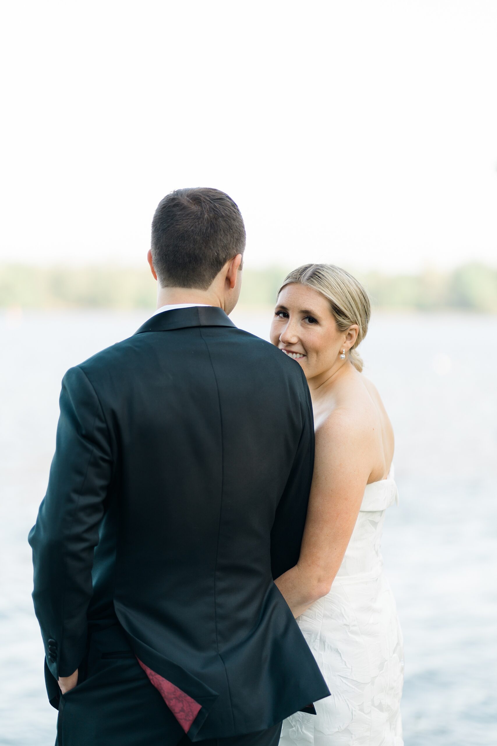 couple stand by the water during portraits 