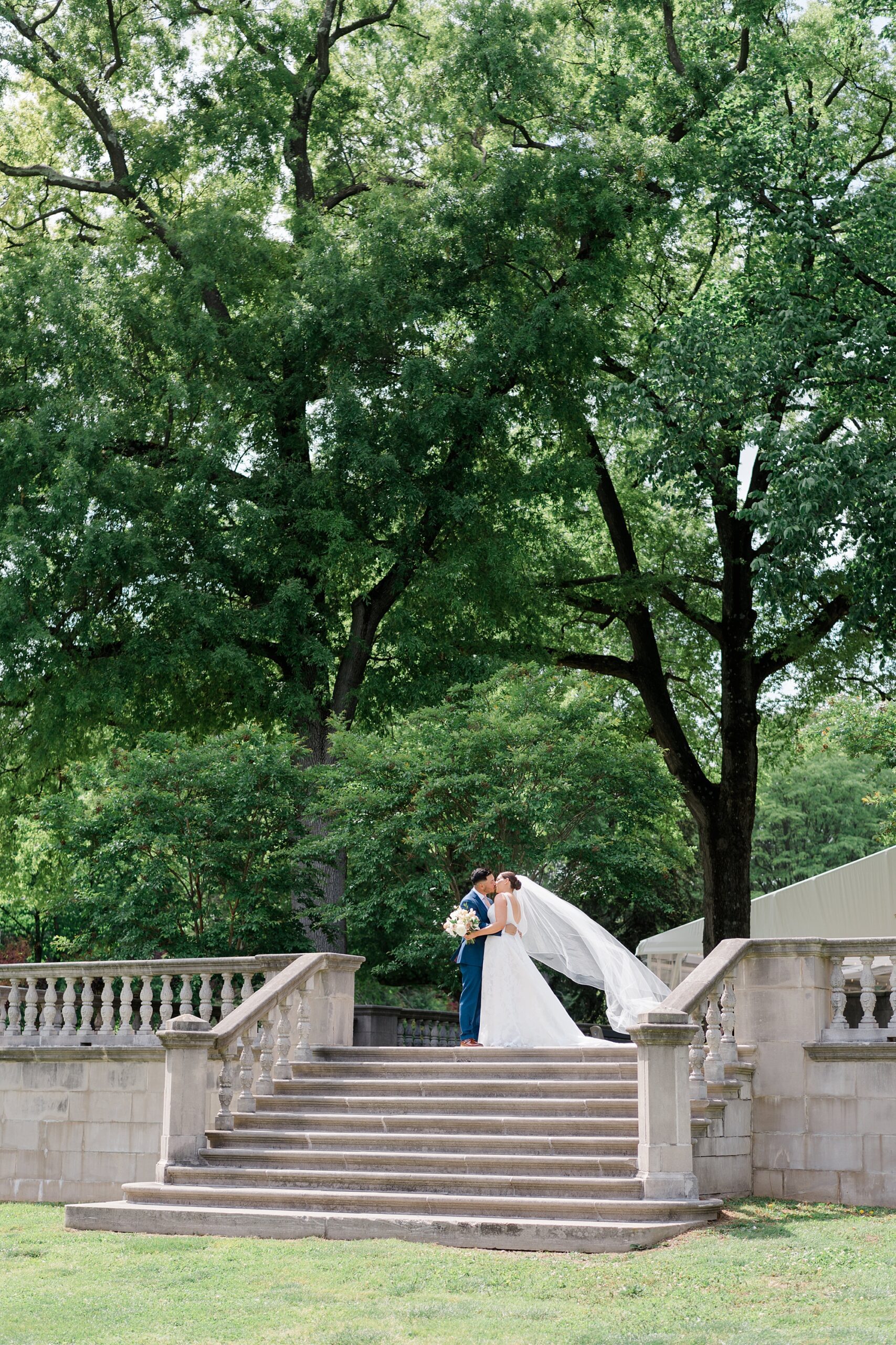 bride and groom kiss on top of stairs at Romantic Curtis Arboretum Wedding