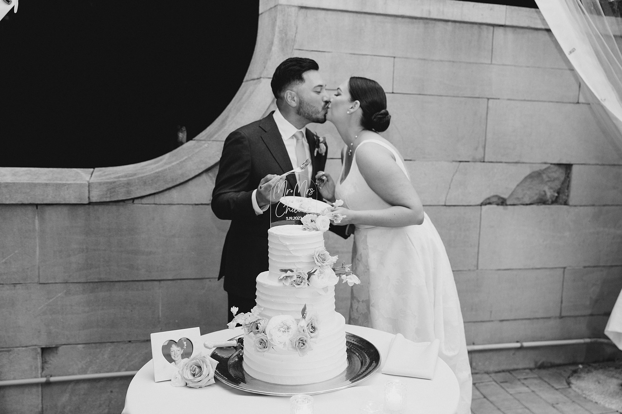 bride and groom kiss during cake cutting 