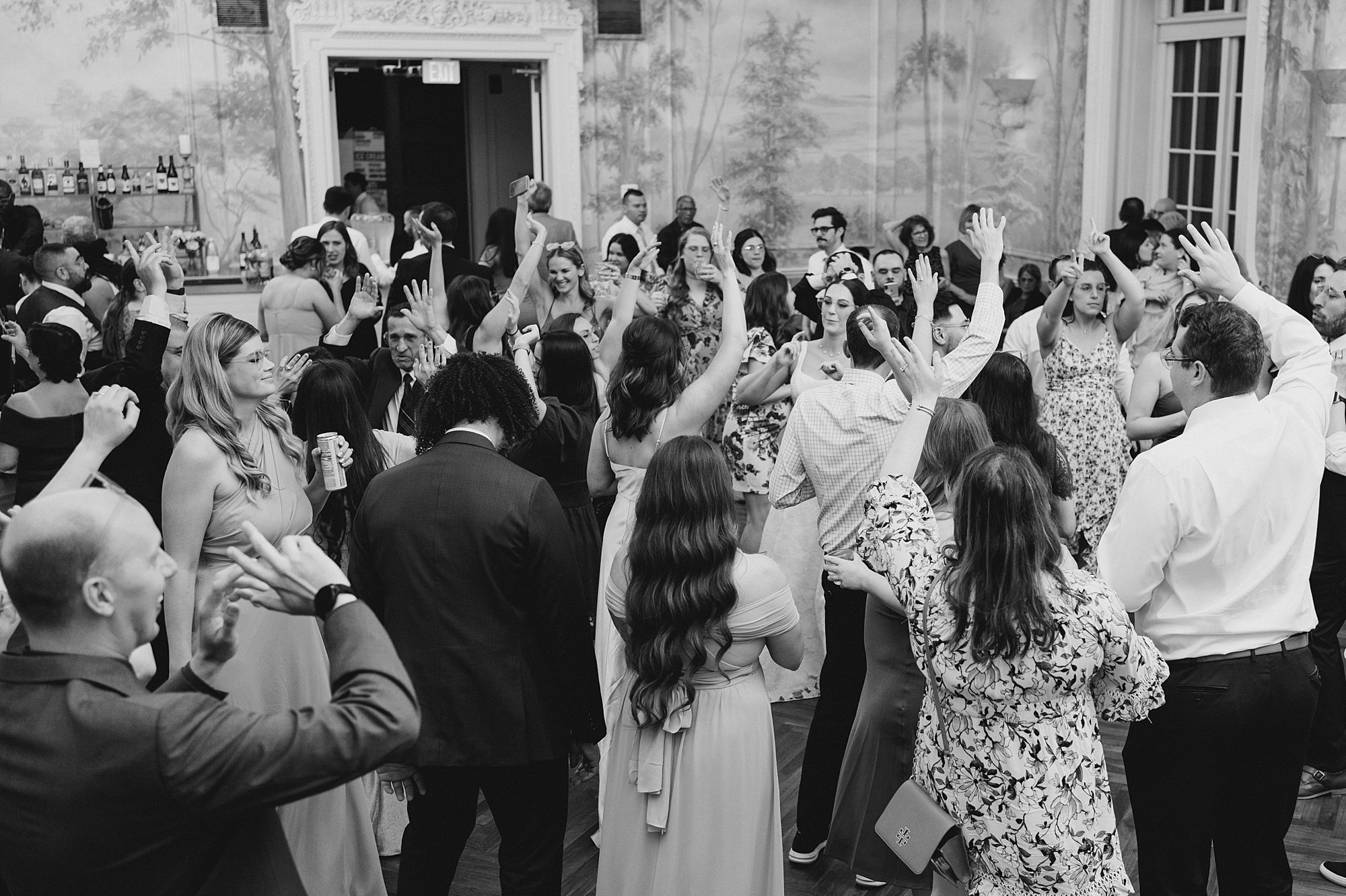 wedding guests dance with bride and groom at wedding reception 
