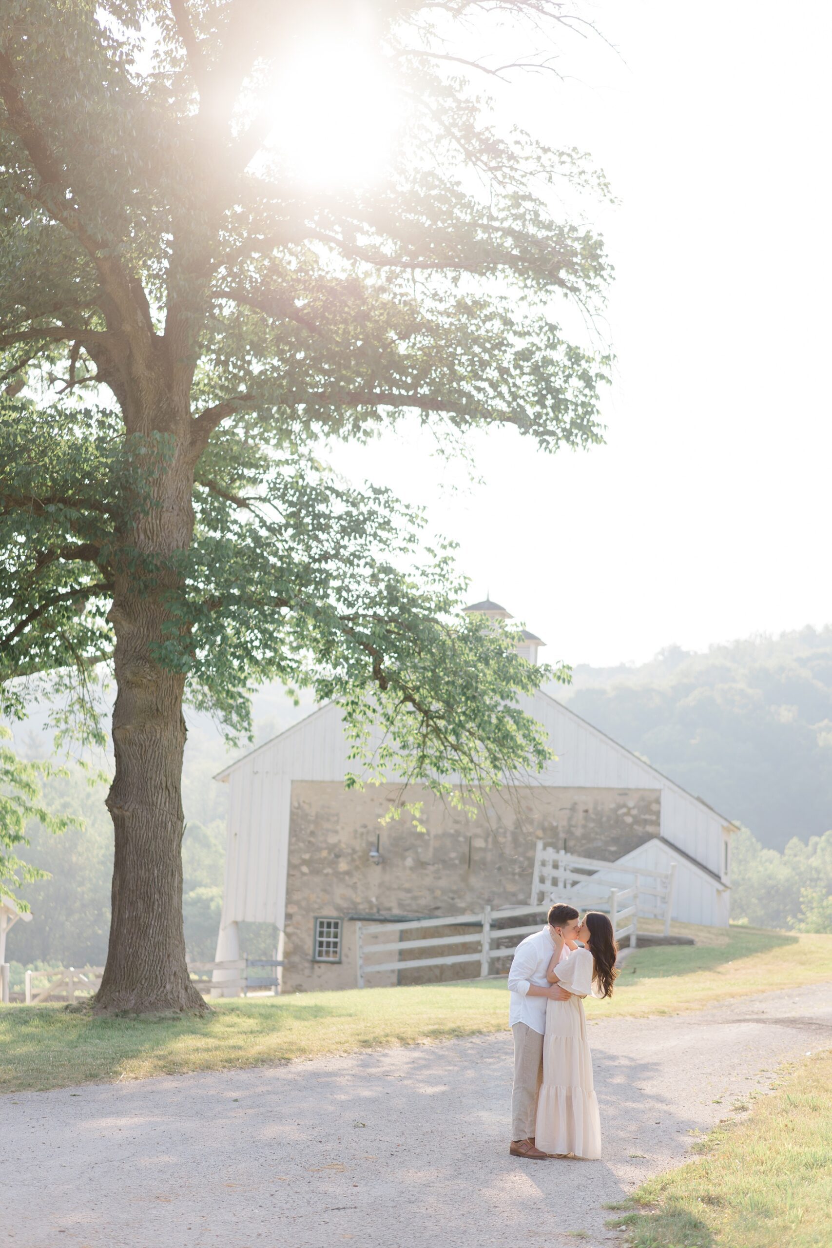 couple kiss in front of barn at sunset in Valley Forge, PA