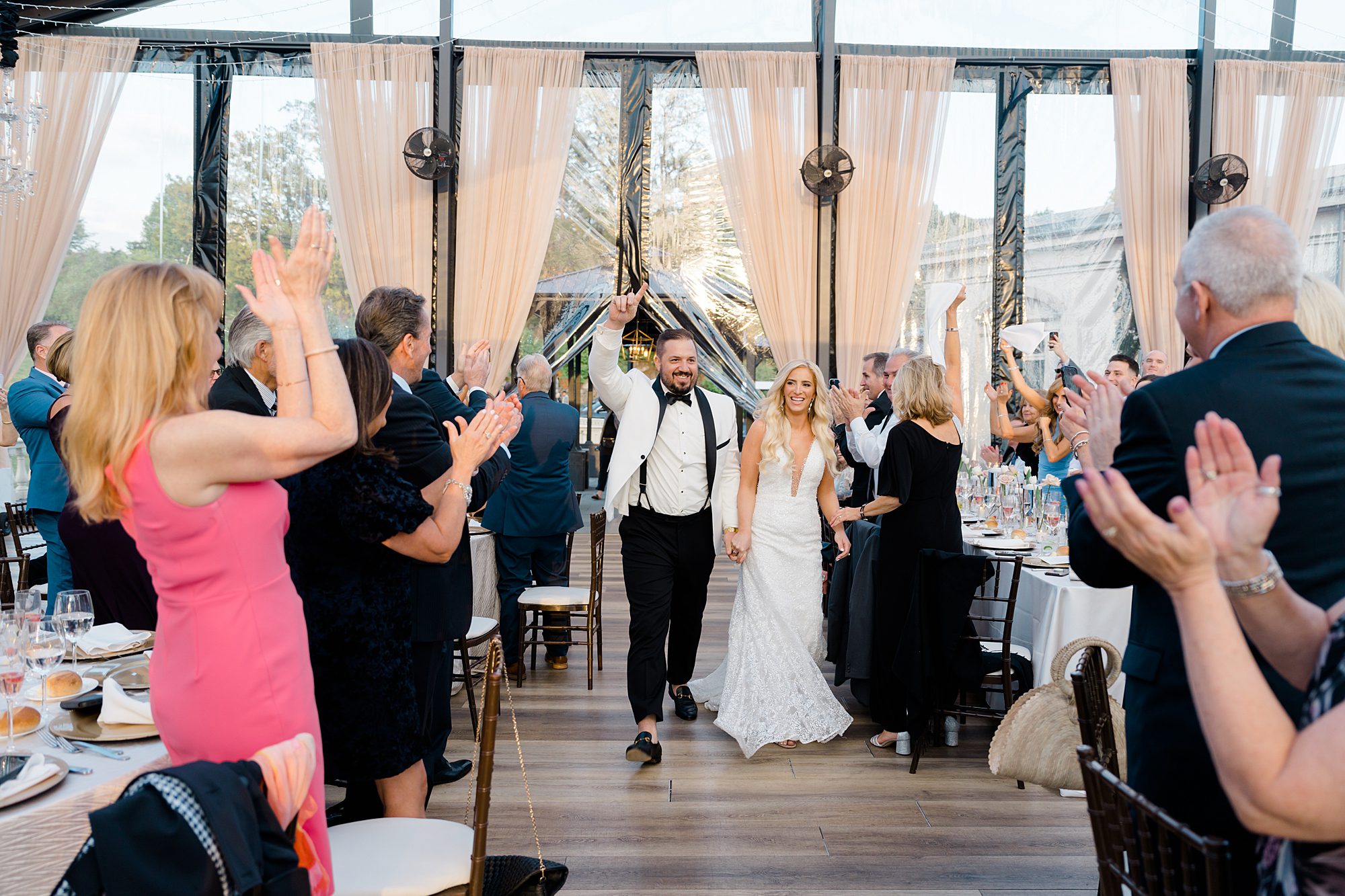 wedding guests cheer as newlyweds enter Water Works Wedding reception