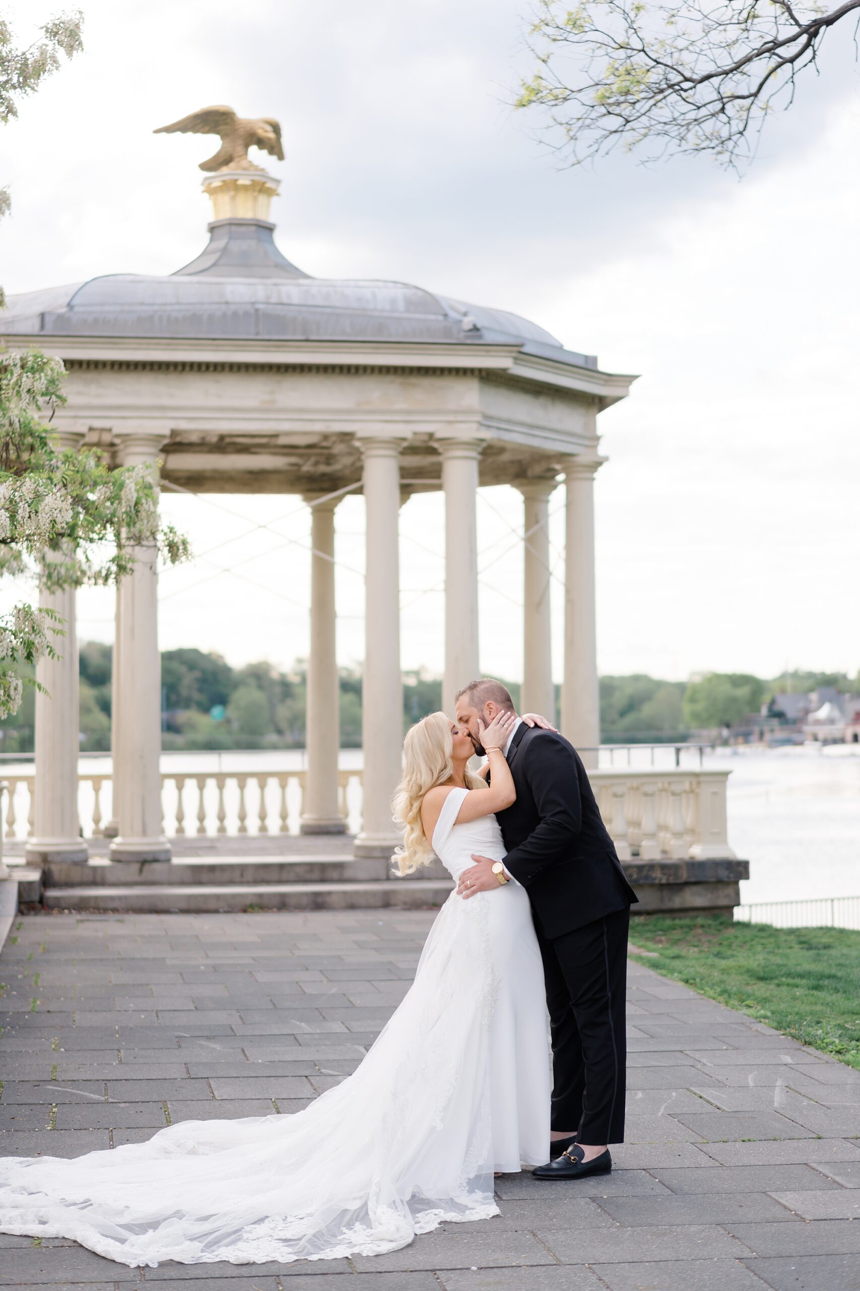 bride and groom kiss by the water at Philadelphia wedding venue