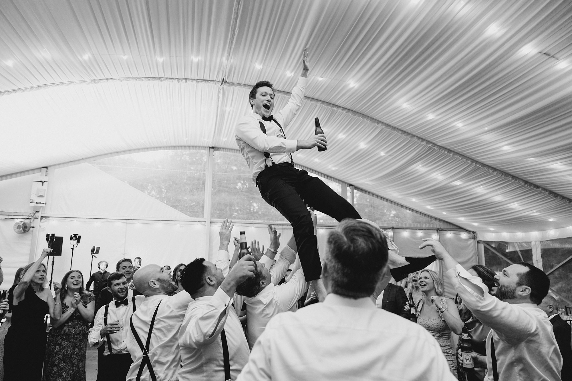 groom is lifted in the air