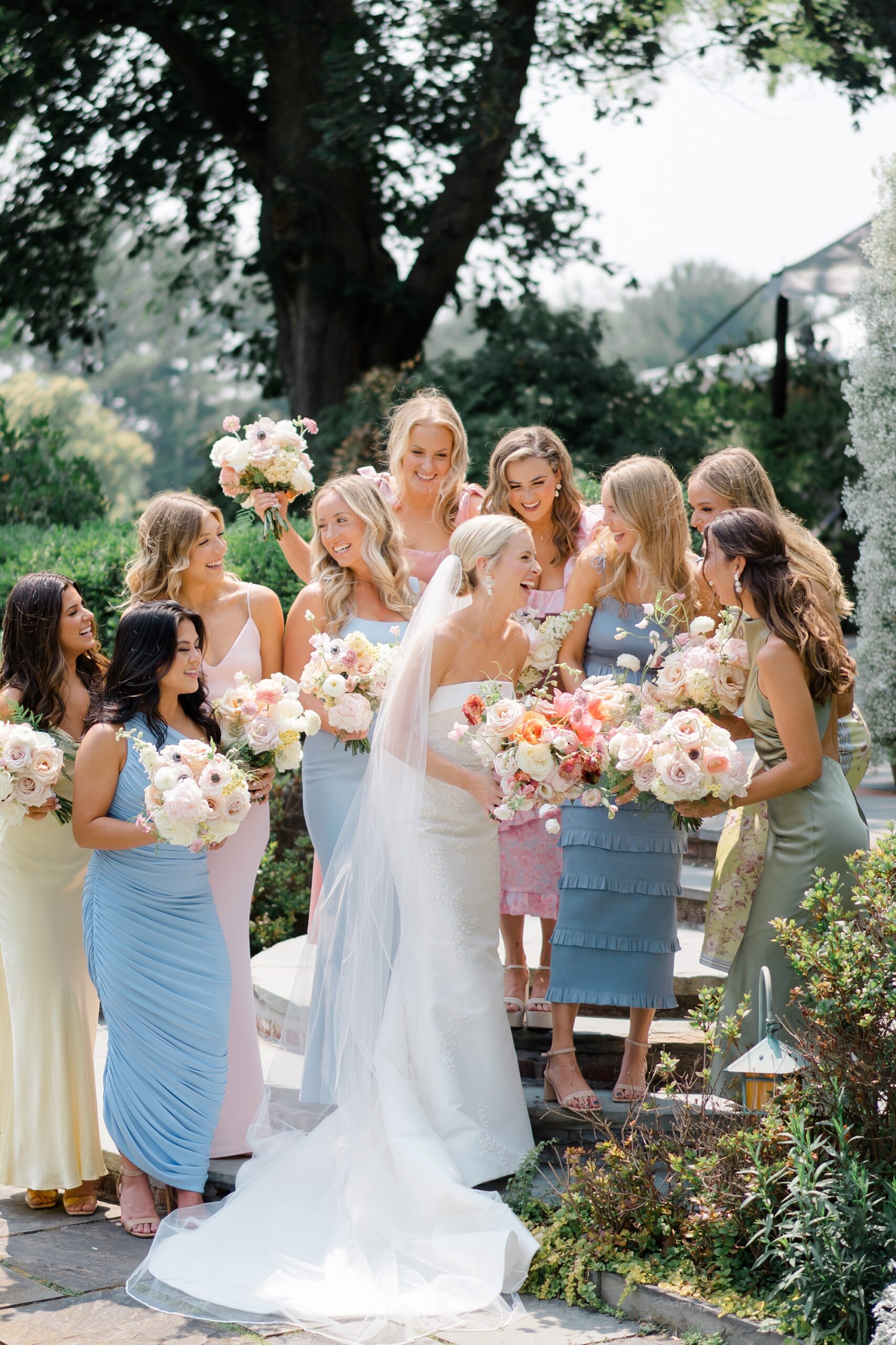 bridesmaids in light, summer colored dresses with bride