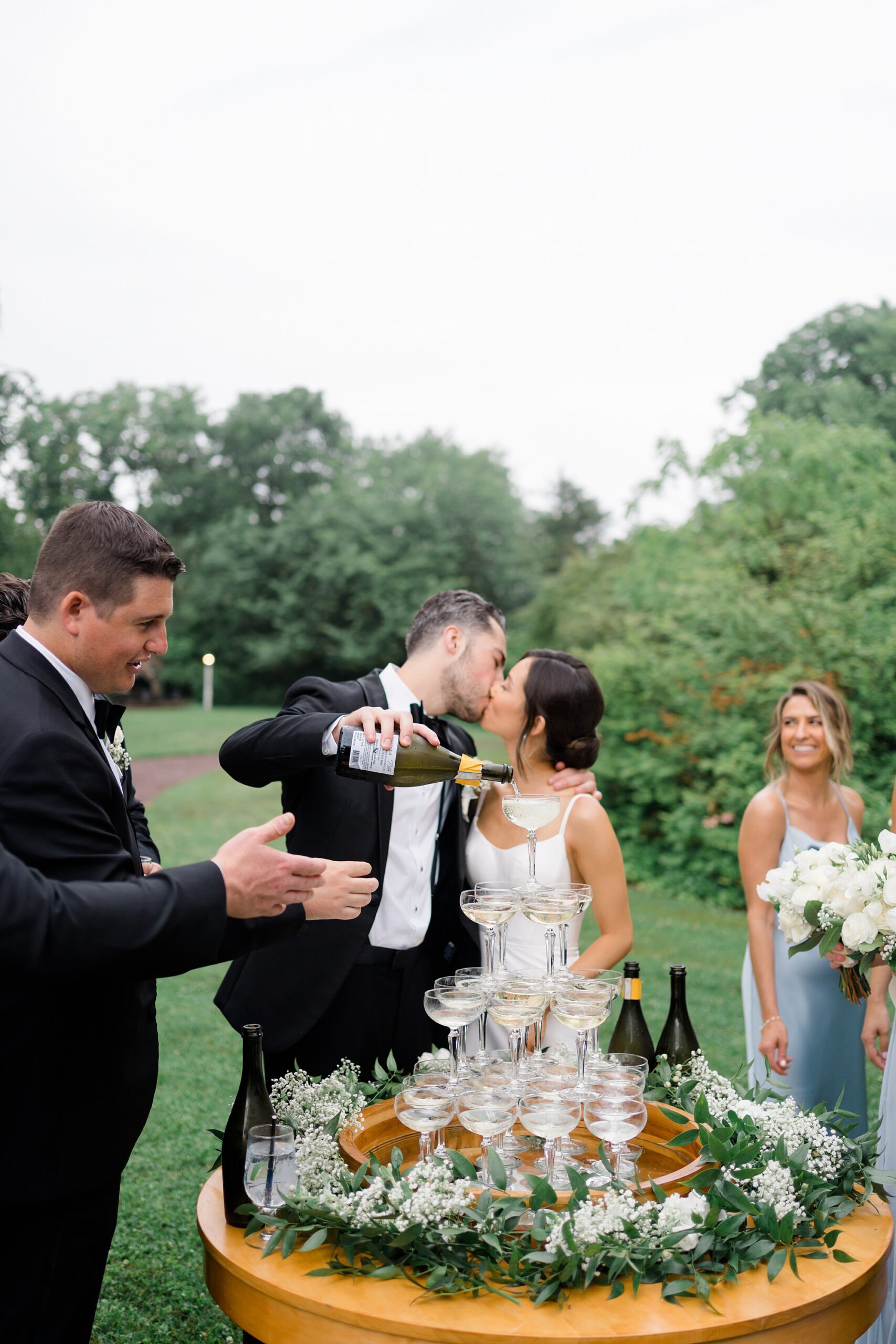 newlyweds kiss as they pour champagne 