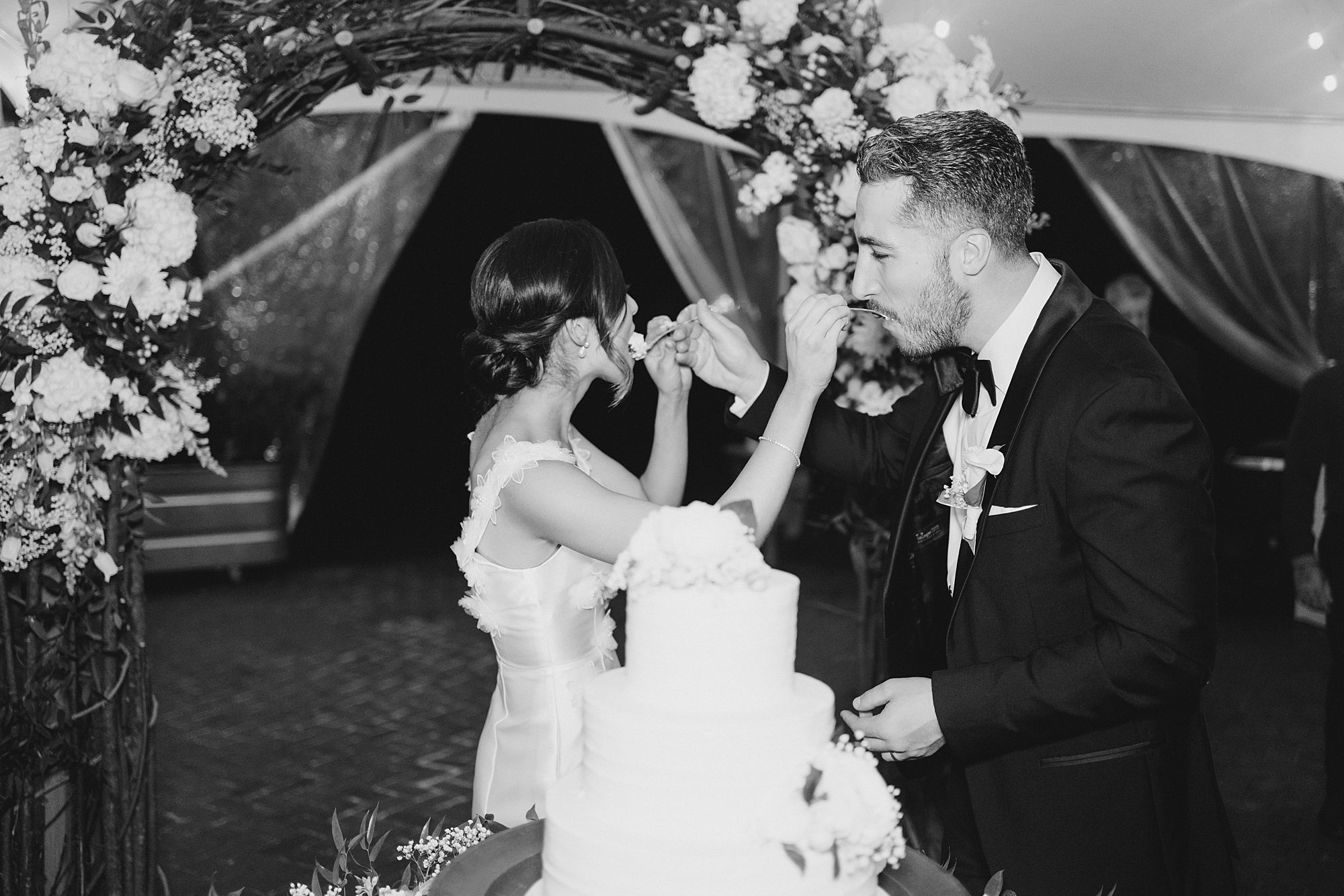 newlyweds feed each other cake 