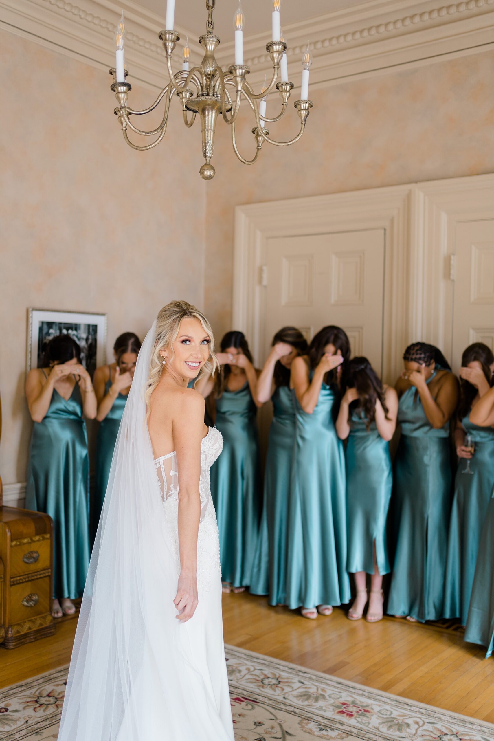 bride's first look with bridesmaids in teal dresses
