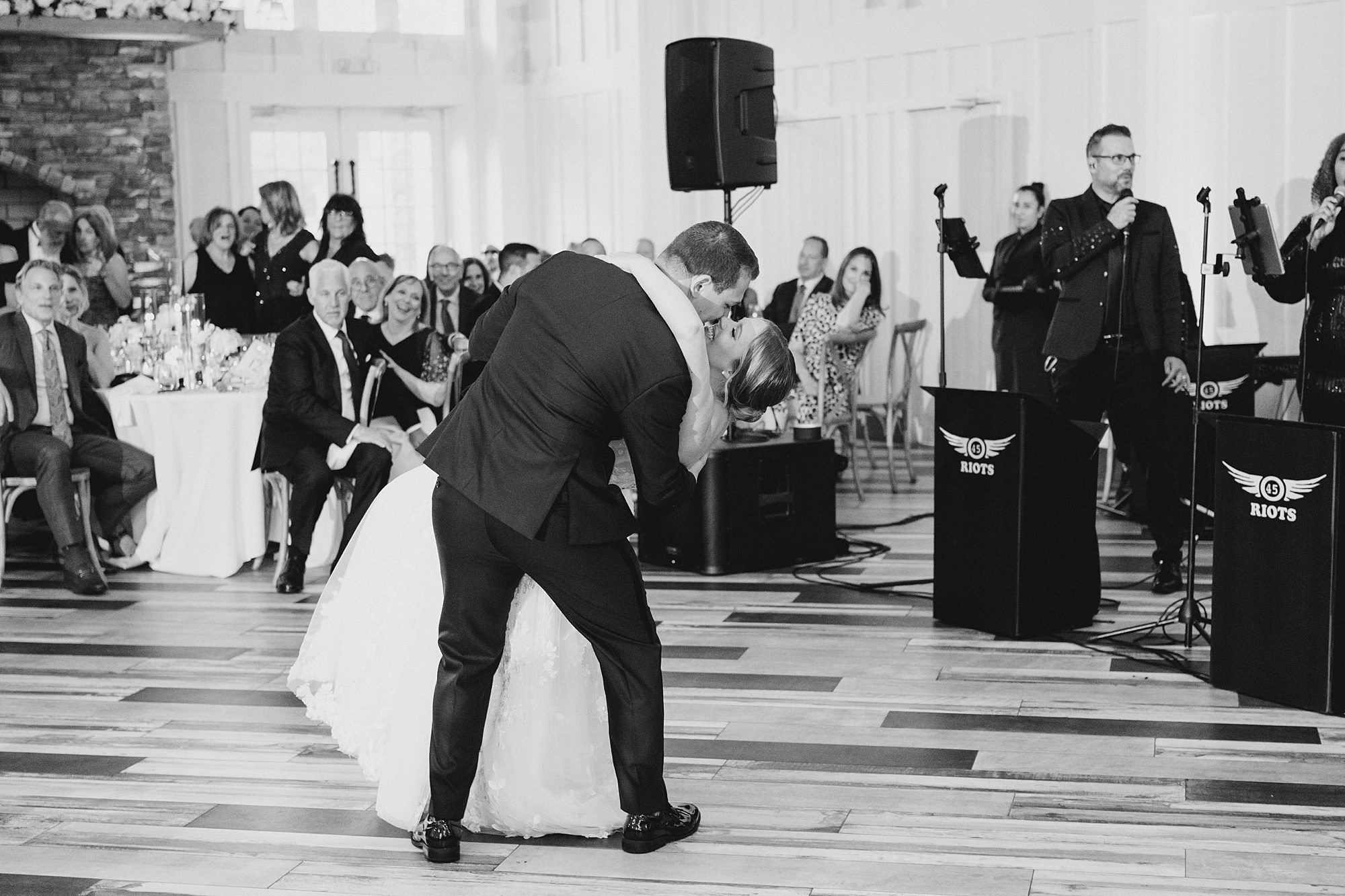 groom dips his bride on the dance floor