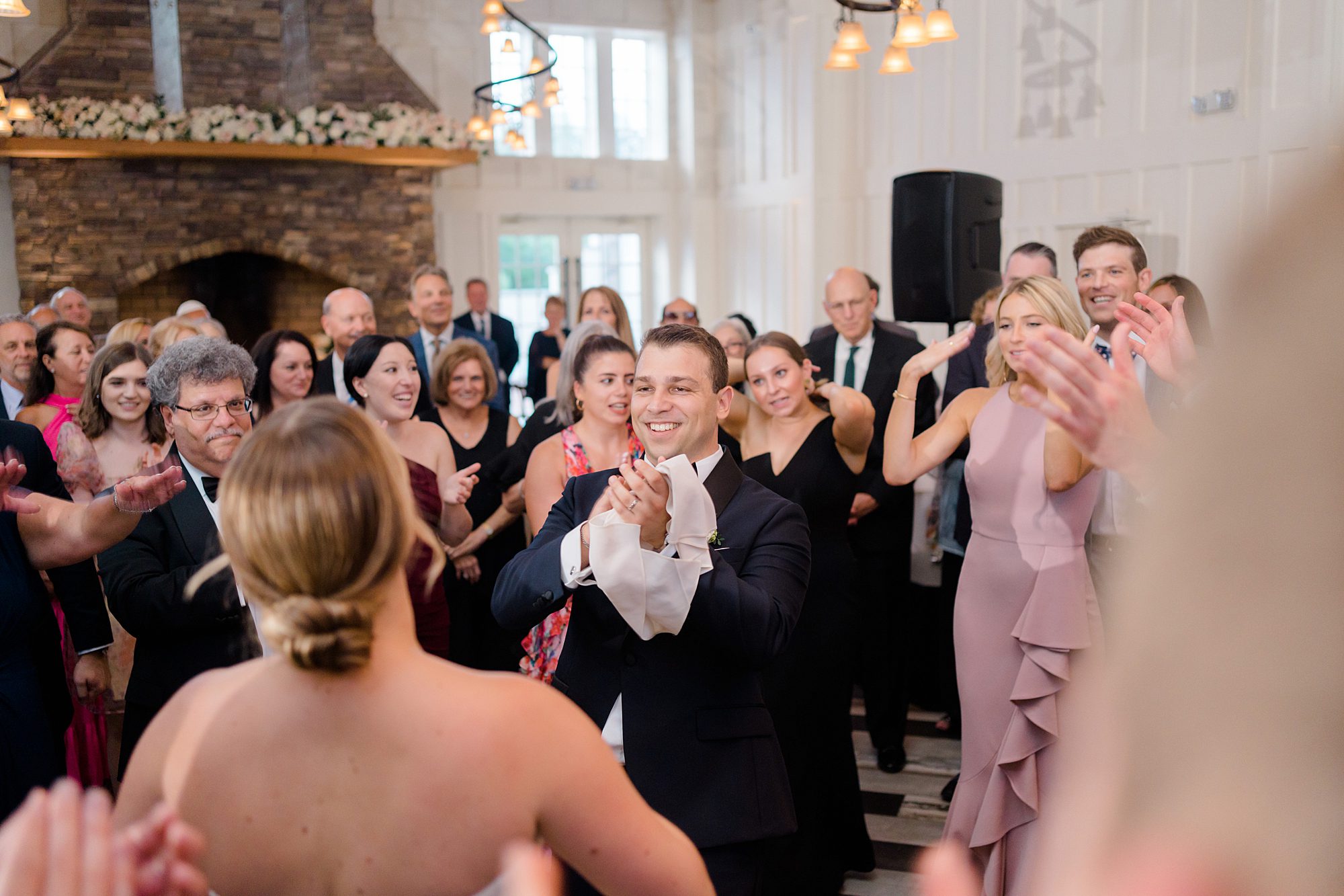 wedding guests dance around bride and groom at wedding reception 