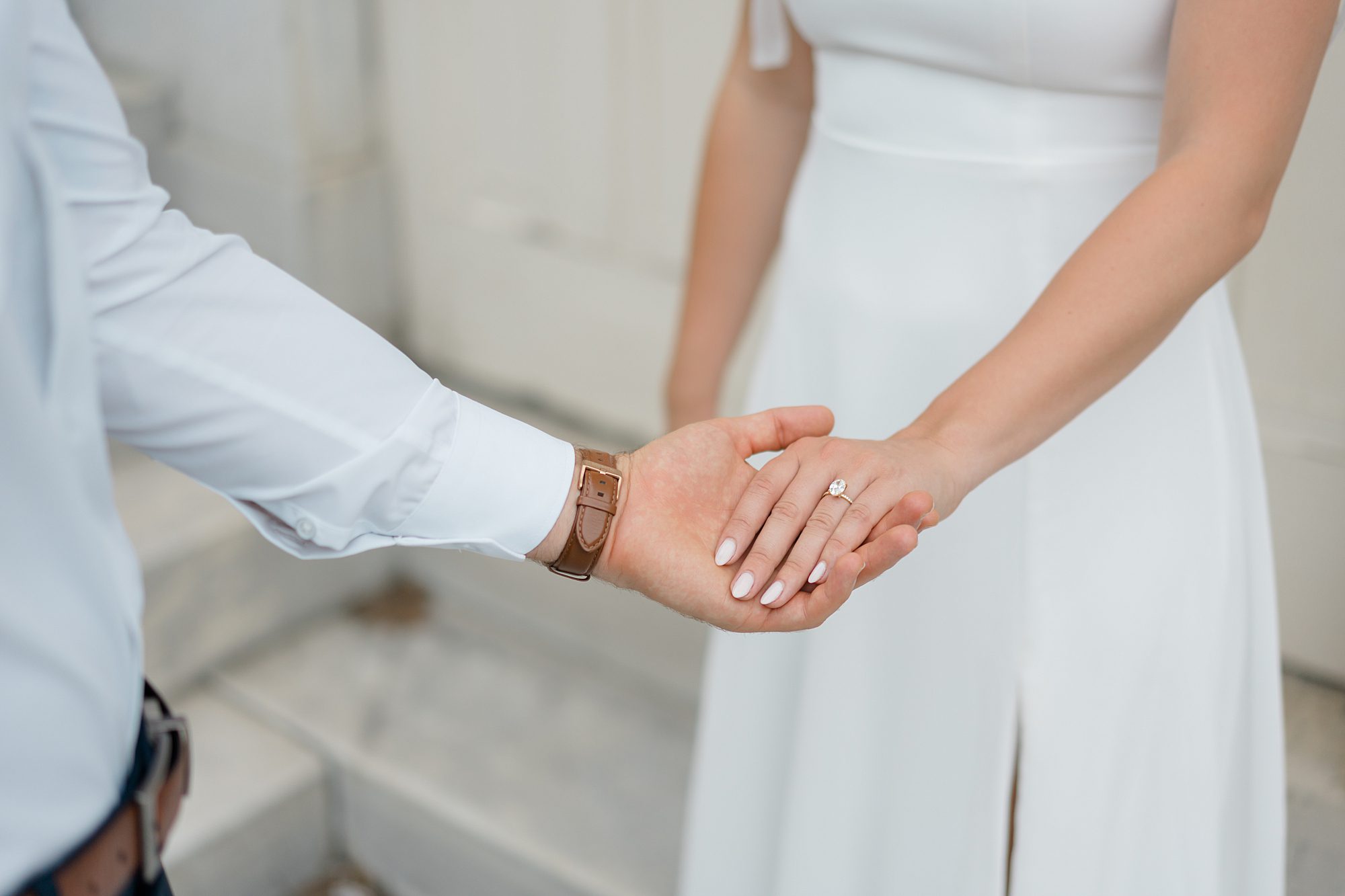 newly engaged couple hold hands